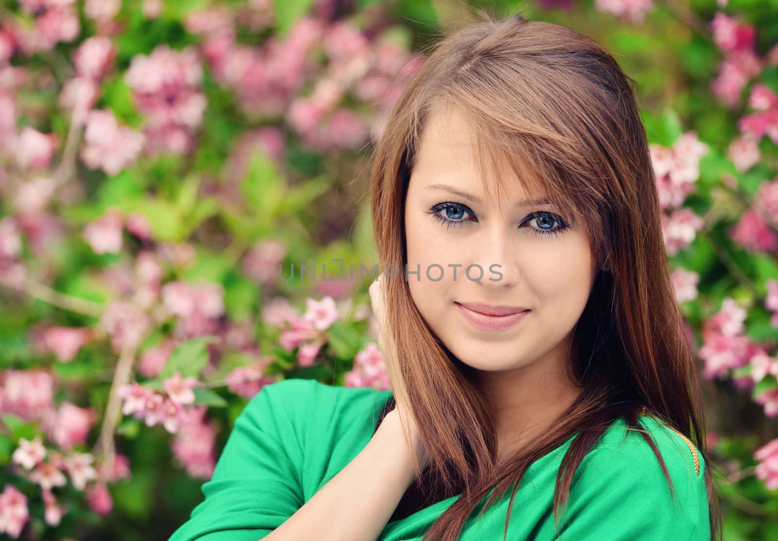 beautiful brunette posing against spring flowers