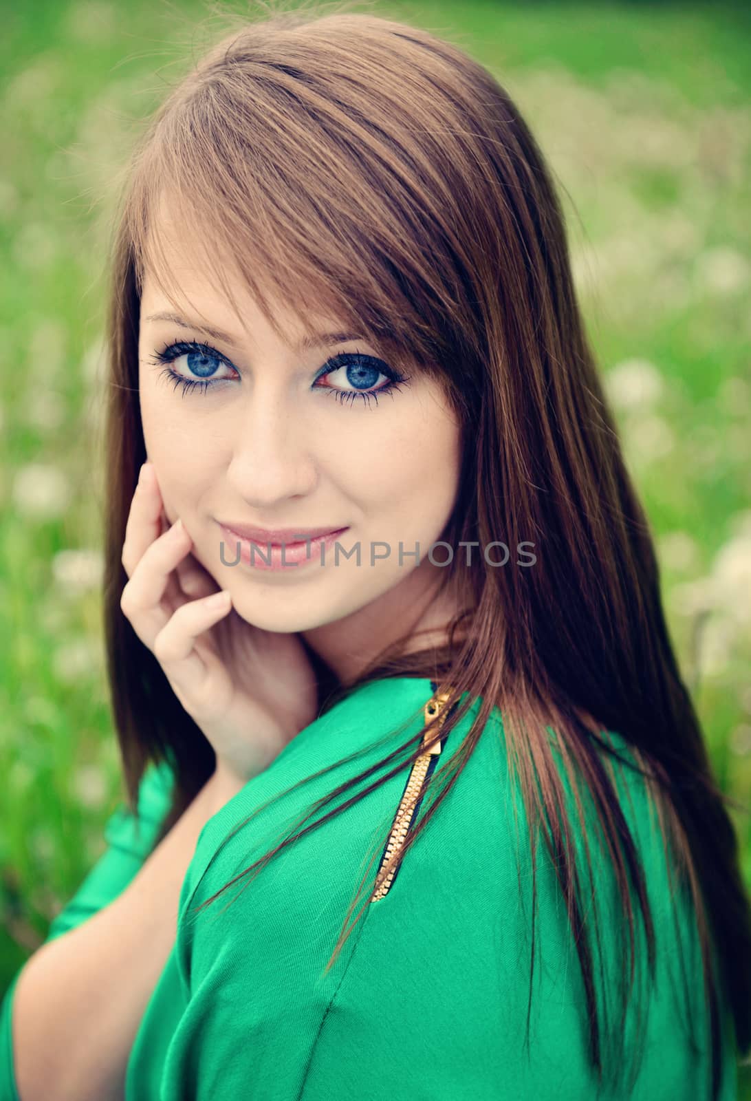 beautiful brunette posing against fresh green background