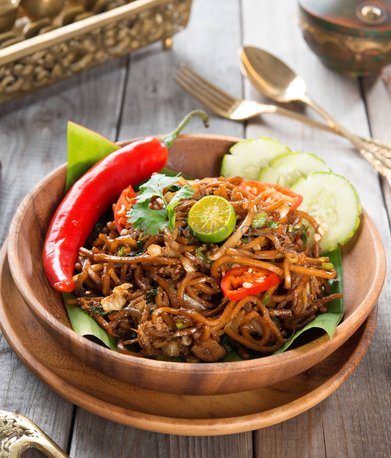 Asian spicy fried noodles, ready to serve on dining table.