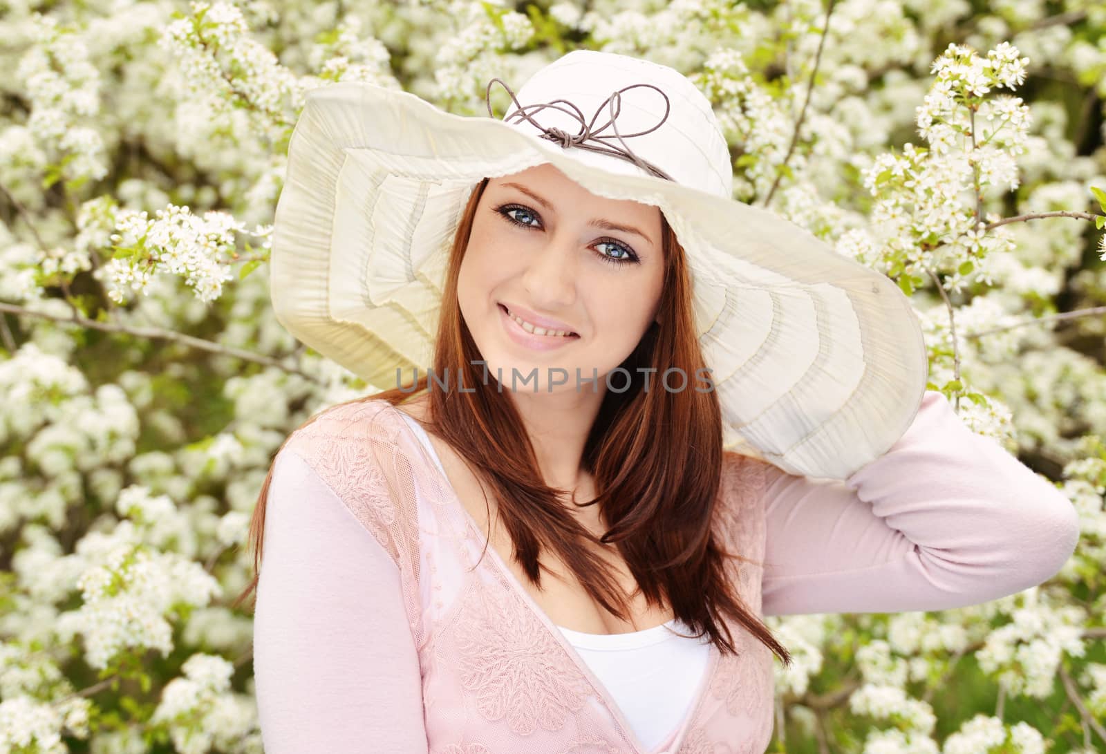 Beautiful girl posing over spring flowers background