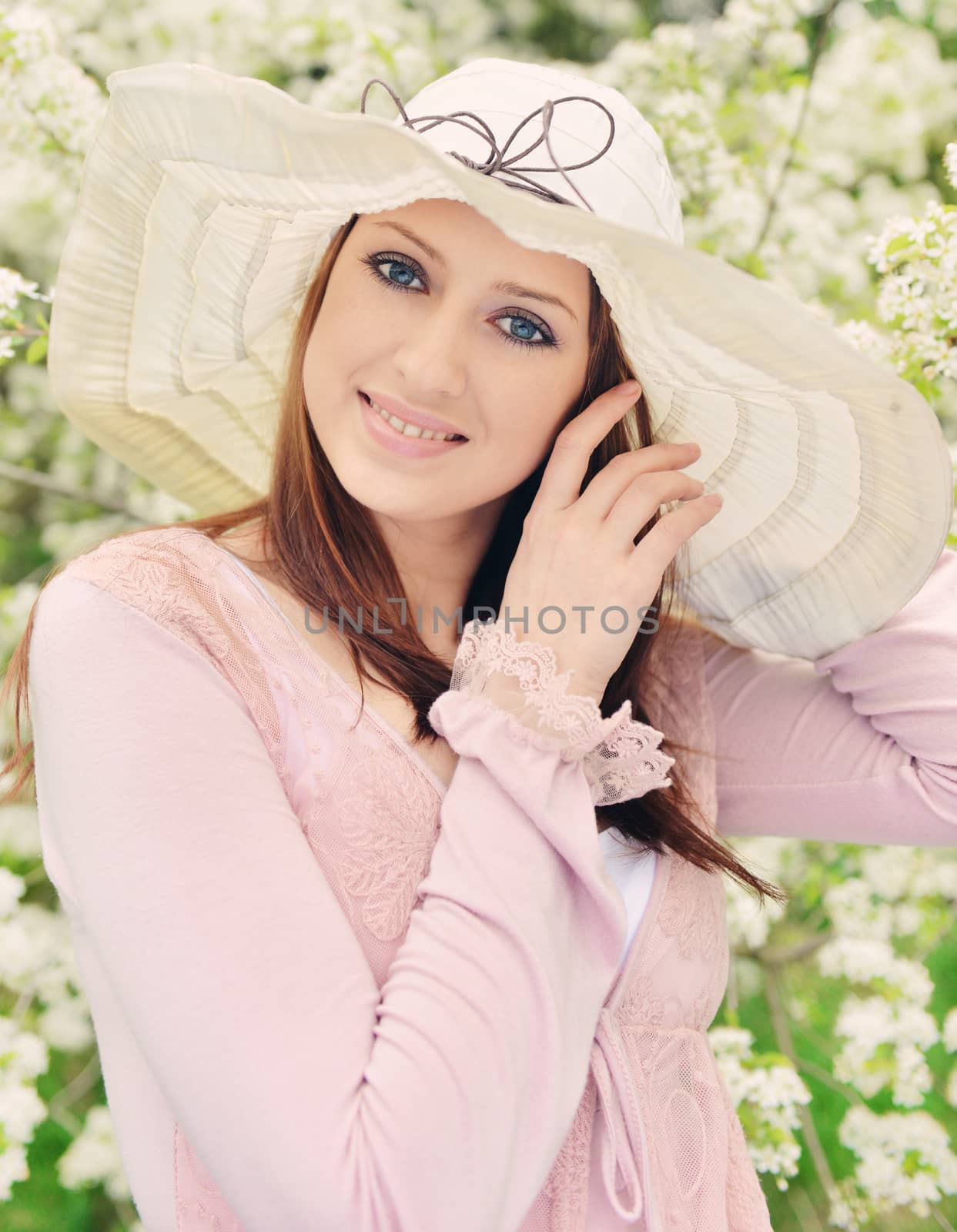 Beautiful girl posing over spring flowers background