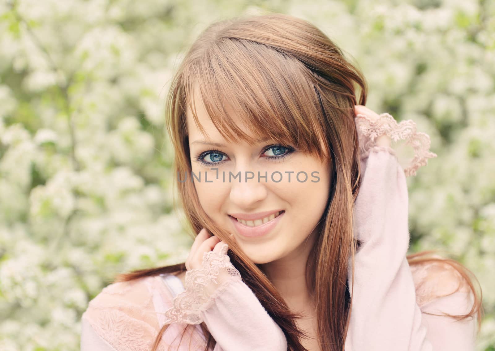 Beautiful girl posing over spring flowers background