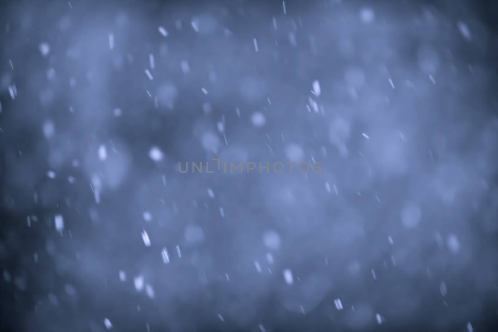 Background of snow flurry falling at night with motion blur