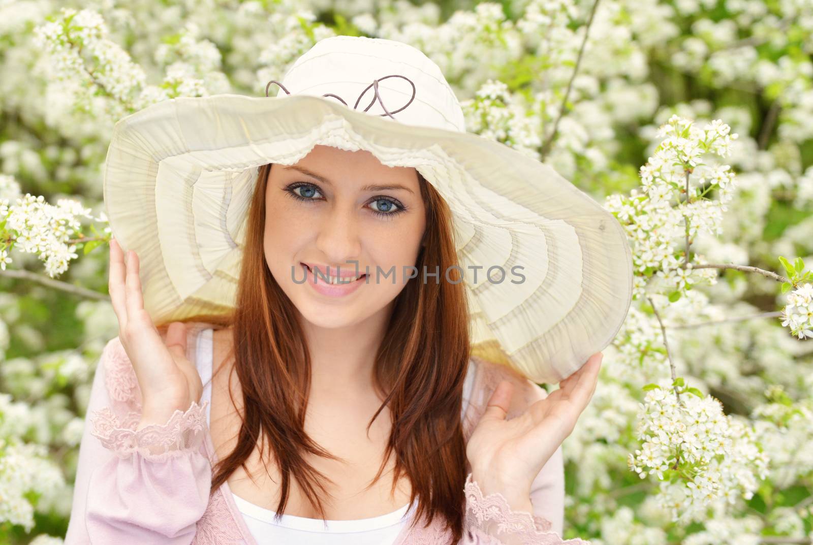 Beautiful girl posing over spring flowers background