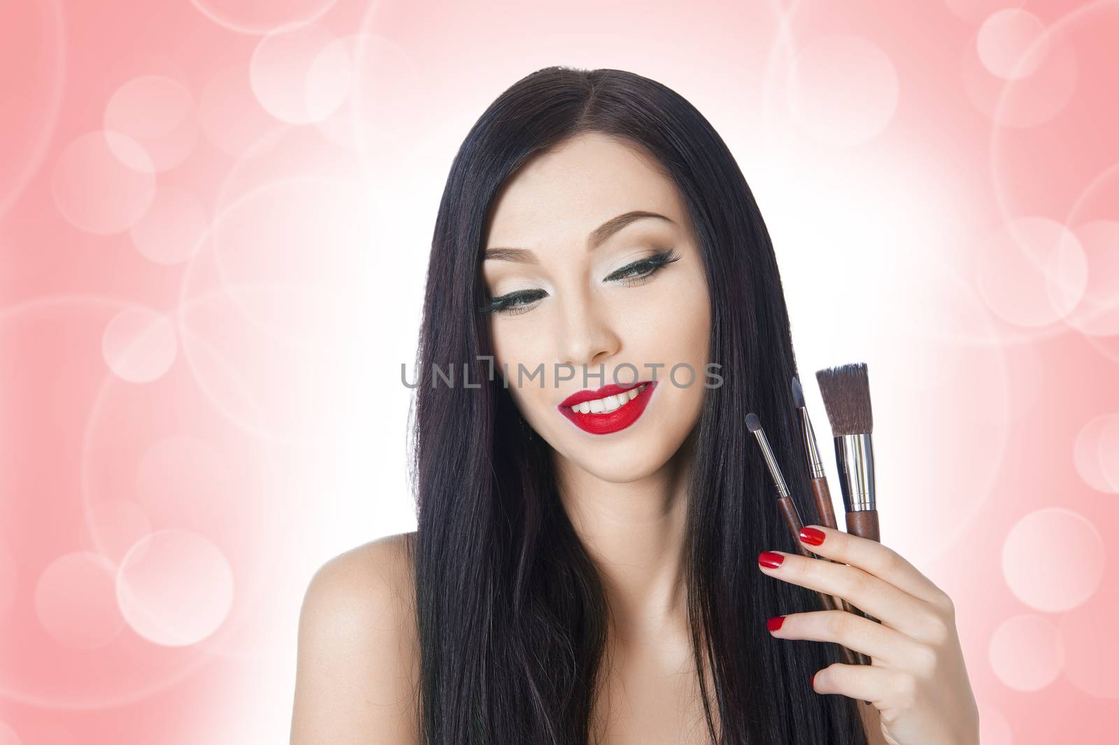 beautiful woman with brushes for makeup on the background bokeh