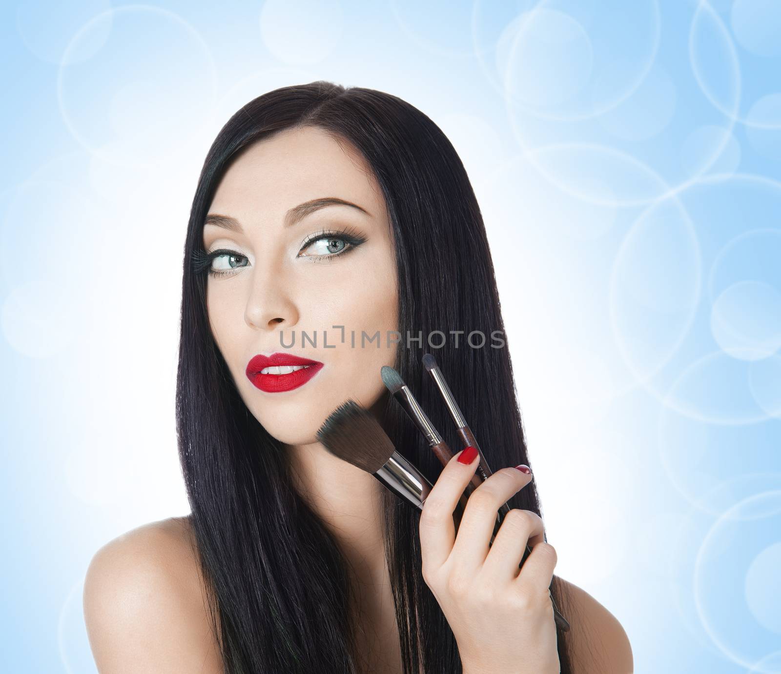 beautiful woman with brushes for makeup on the background bokeh