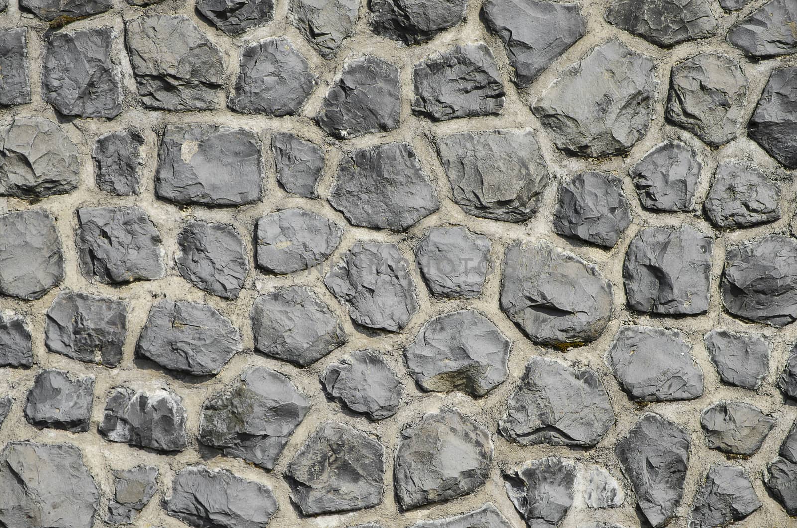 irregular wall made out of stone and mortar texture background