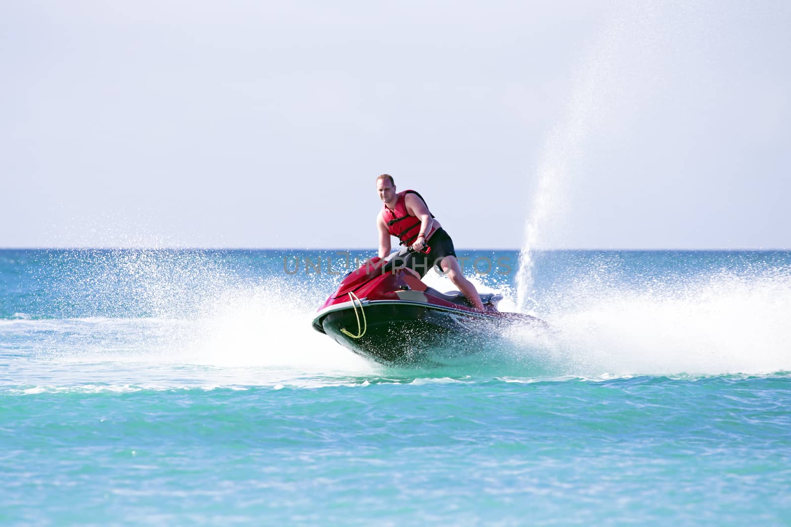 Young guy cruising on the atlantic ocean on a jet ski by devy
