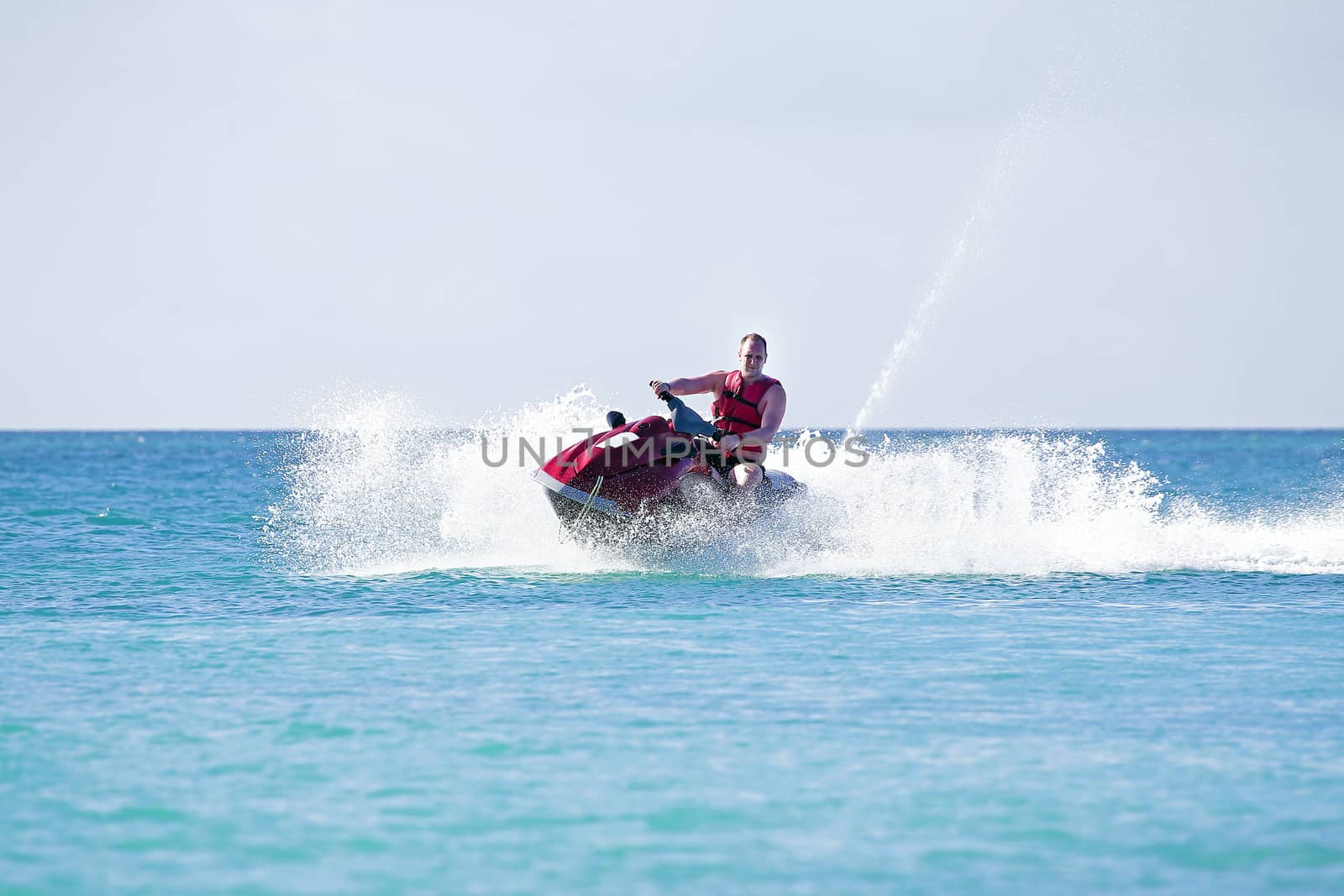 Young guy cruising on a jetski on the caribbean sea by devy