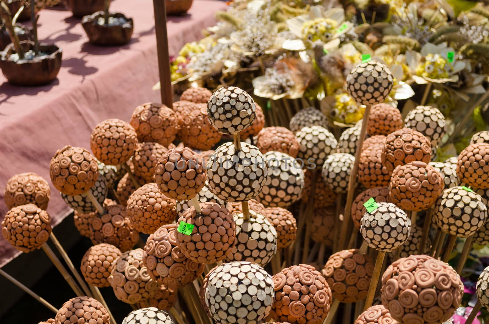 handmade wooden and clay balls ornaments on sticks at village fair