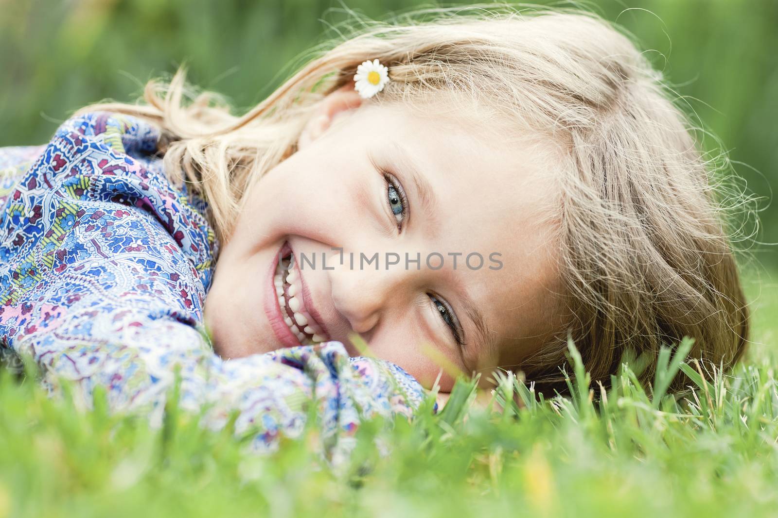 Little adorable girl lying on grass laughing