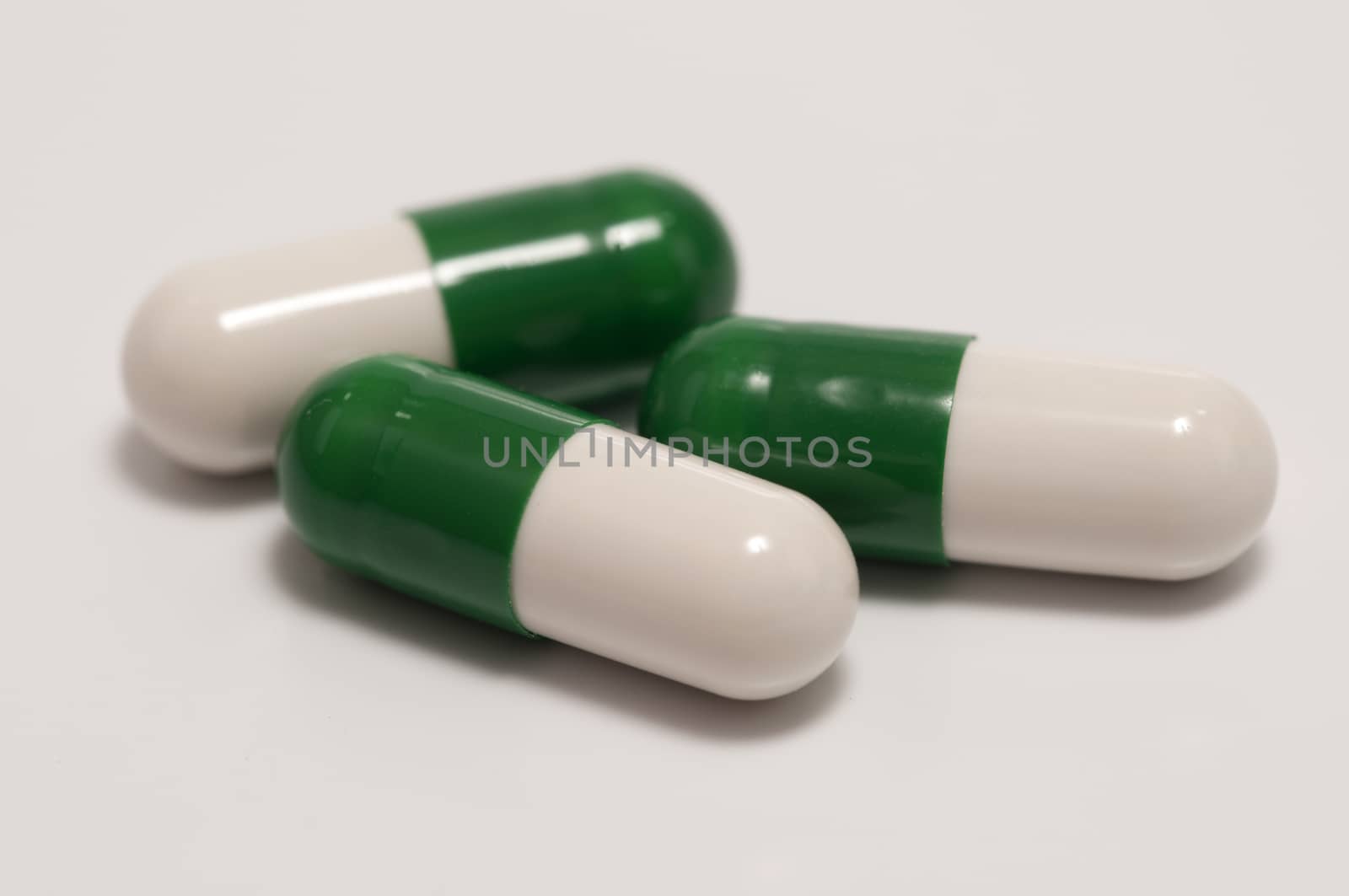 Three capsules or pills on white background