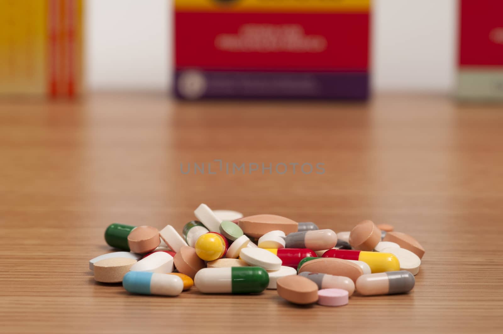 A bunch of capsule and pills with medicine boxes on the background