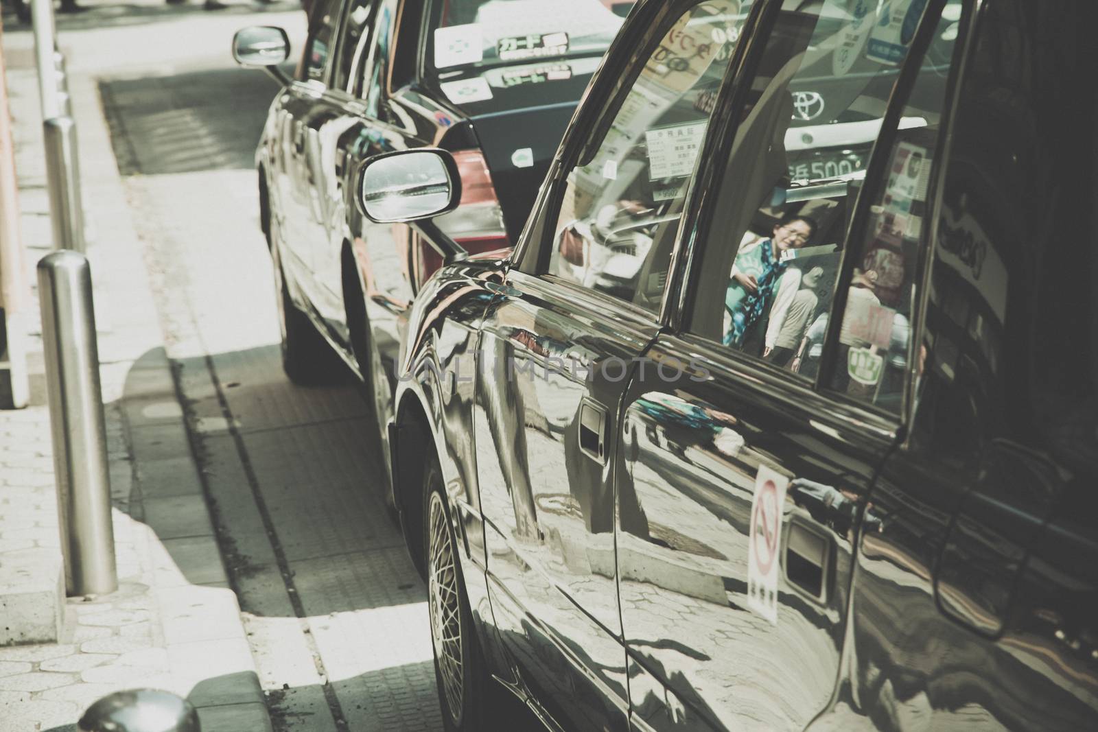 TOKYO, JAPAN-APRIL 14: Taxi waiting area near the Ueno Park in Tokyo on APRIL 14, 2014 in Tokyo, Several taxi cabs are waiting in line along the sidewalk.