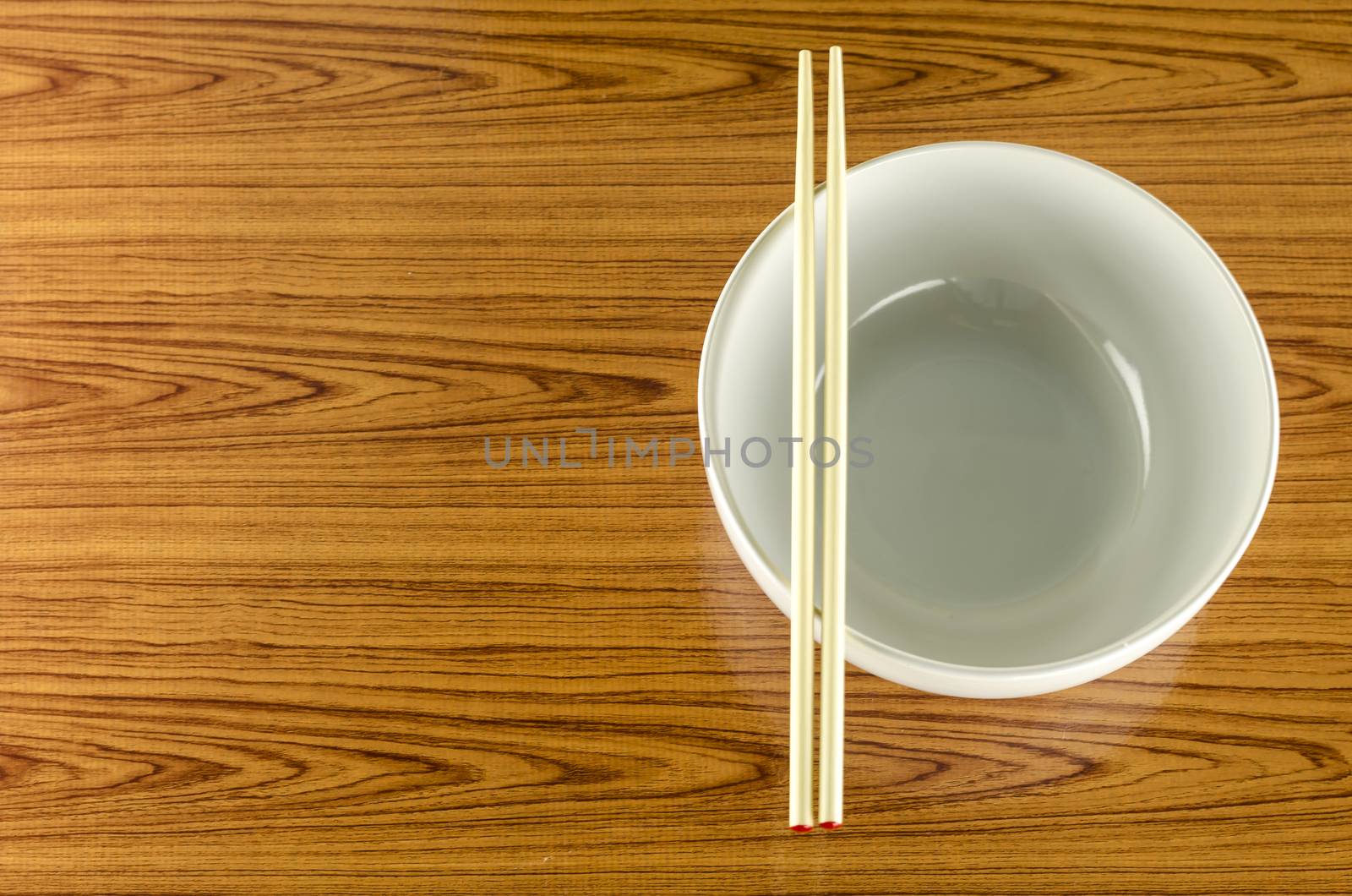 empty white bowl with chopstick on wood table background