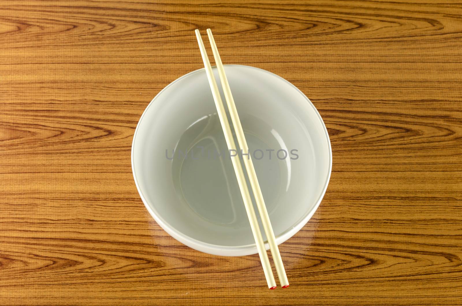 empty white bowl with chopstick on wood table background