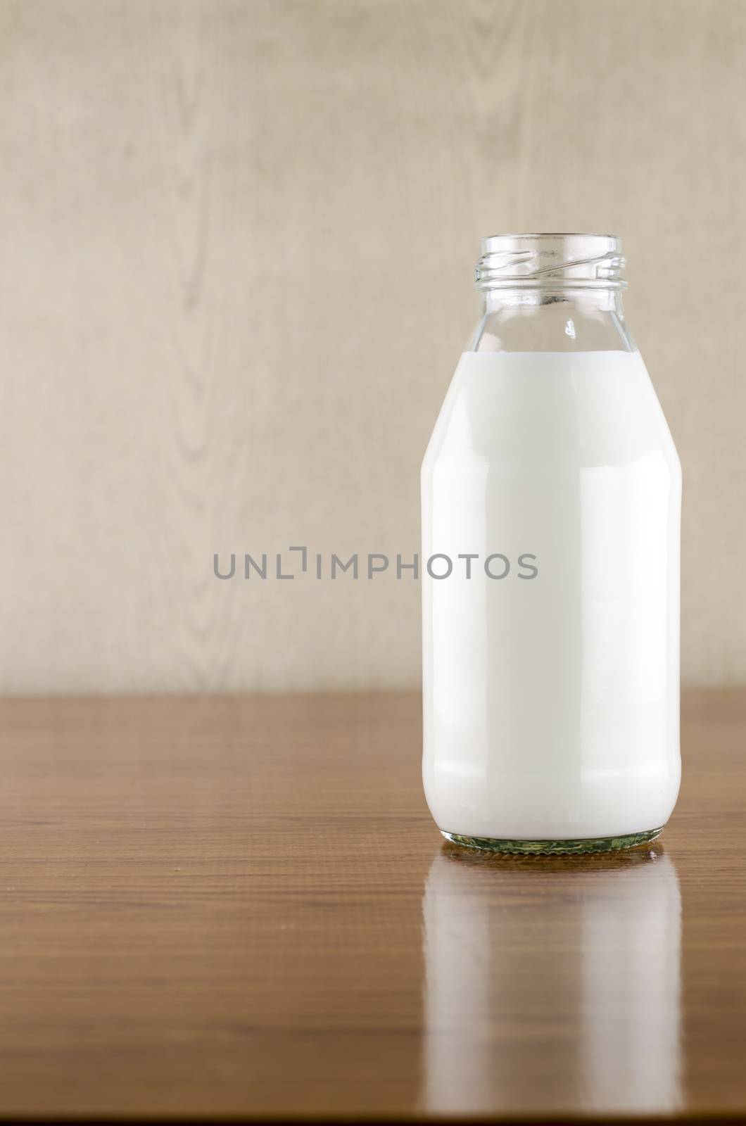 milk in a glass of bottle on wood table background