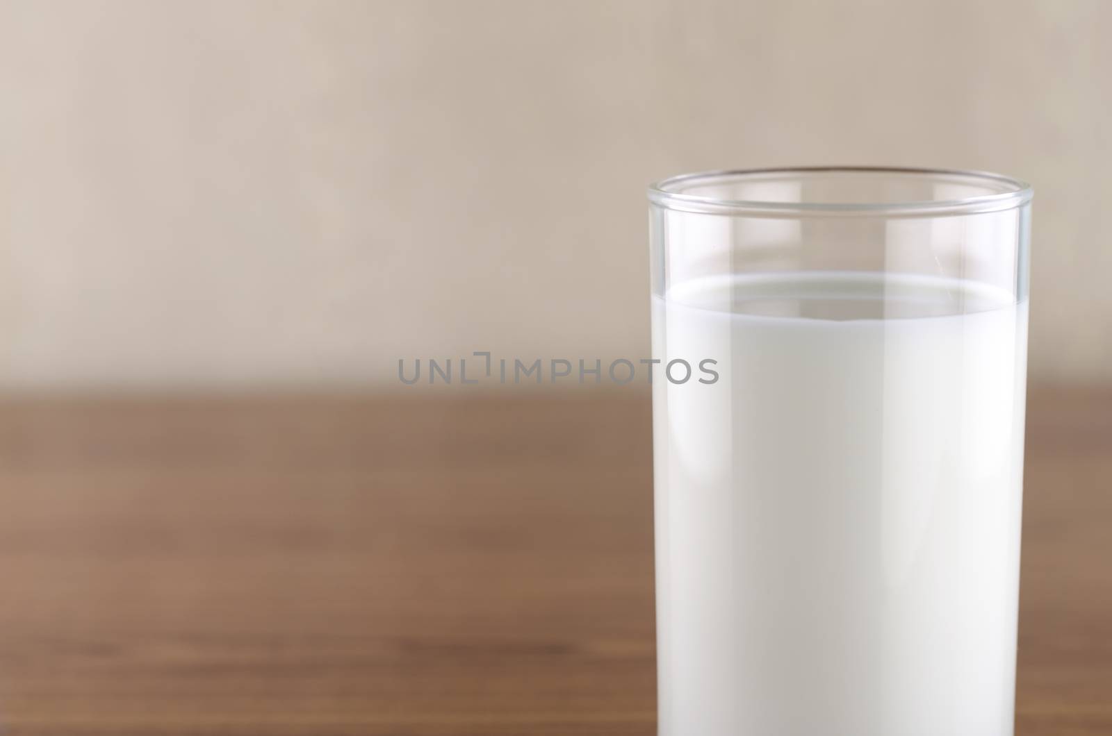 milk in a glass on wood background
