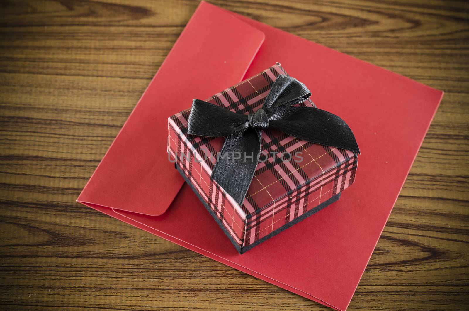 red gift box and envelope on wood background