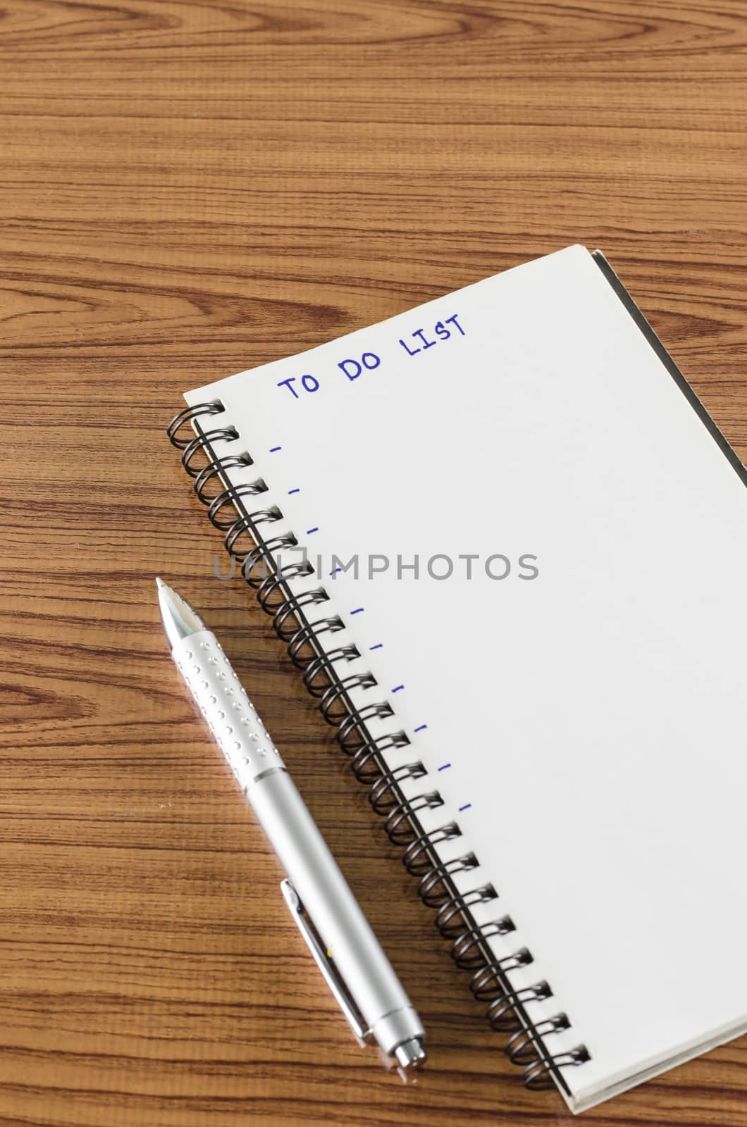 notebook and pen with word to do list on wood background
