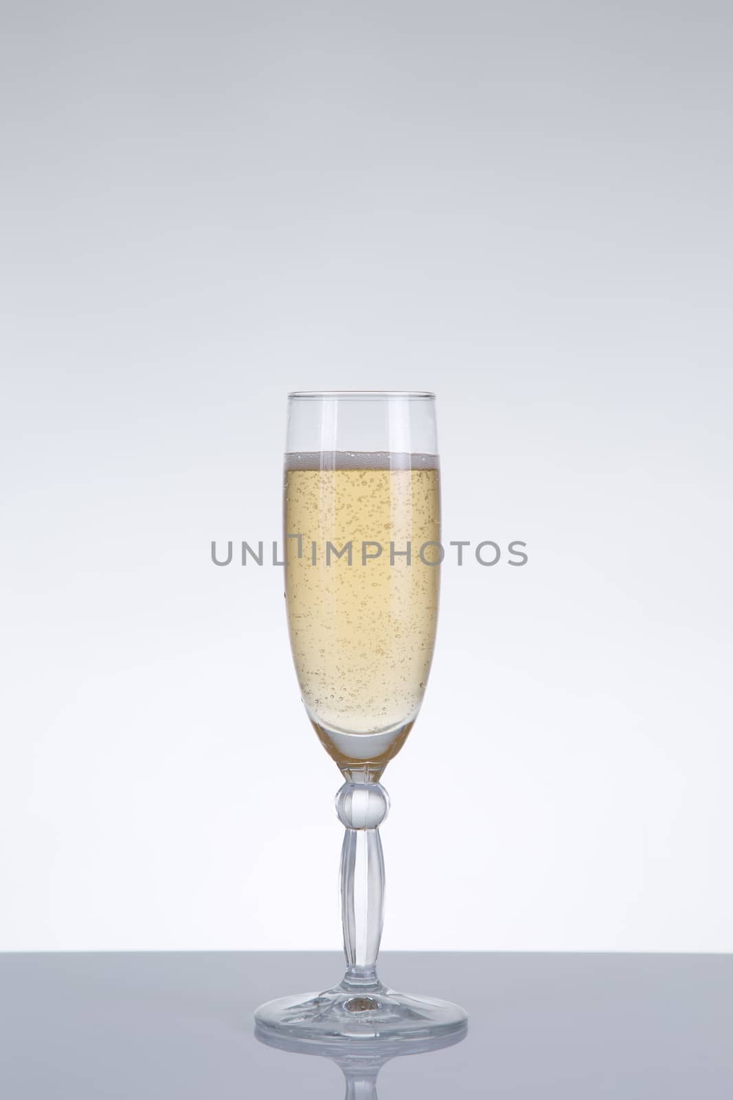 Glass of champagne with natural reflection for New Year, studio shot on grey background 
