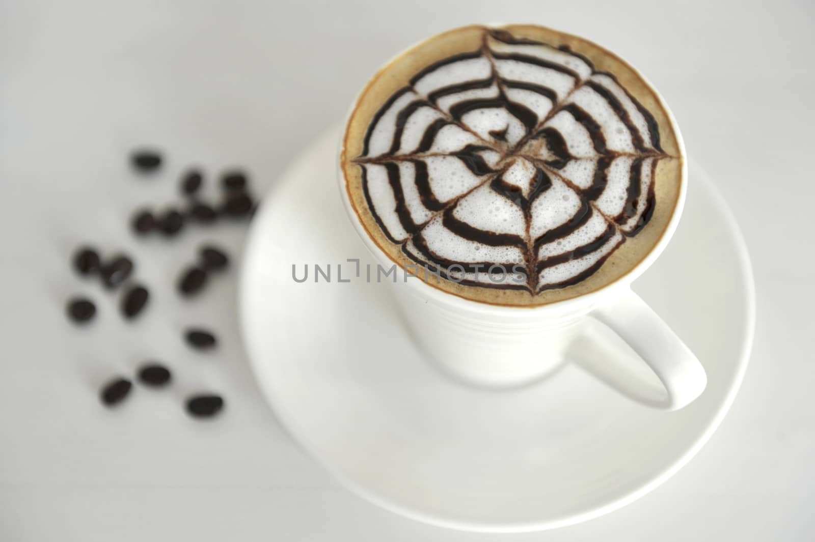 Large cup of coffee decorated with milk froth and chocolate draw by think4photop