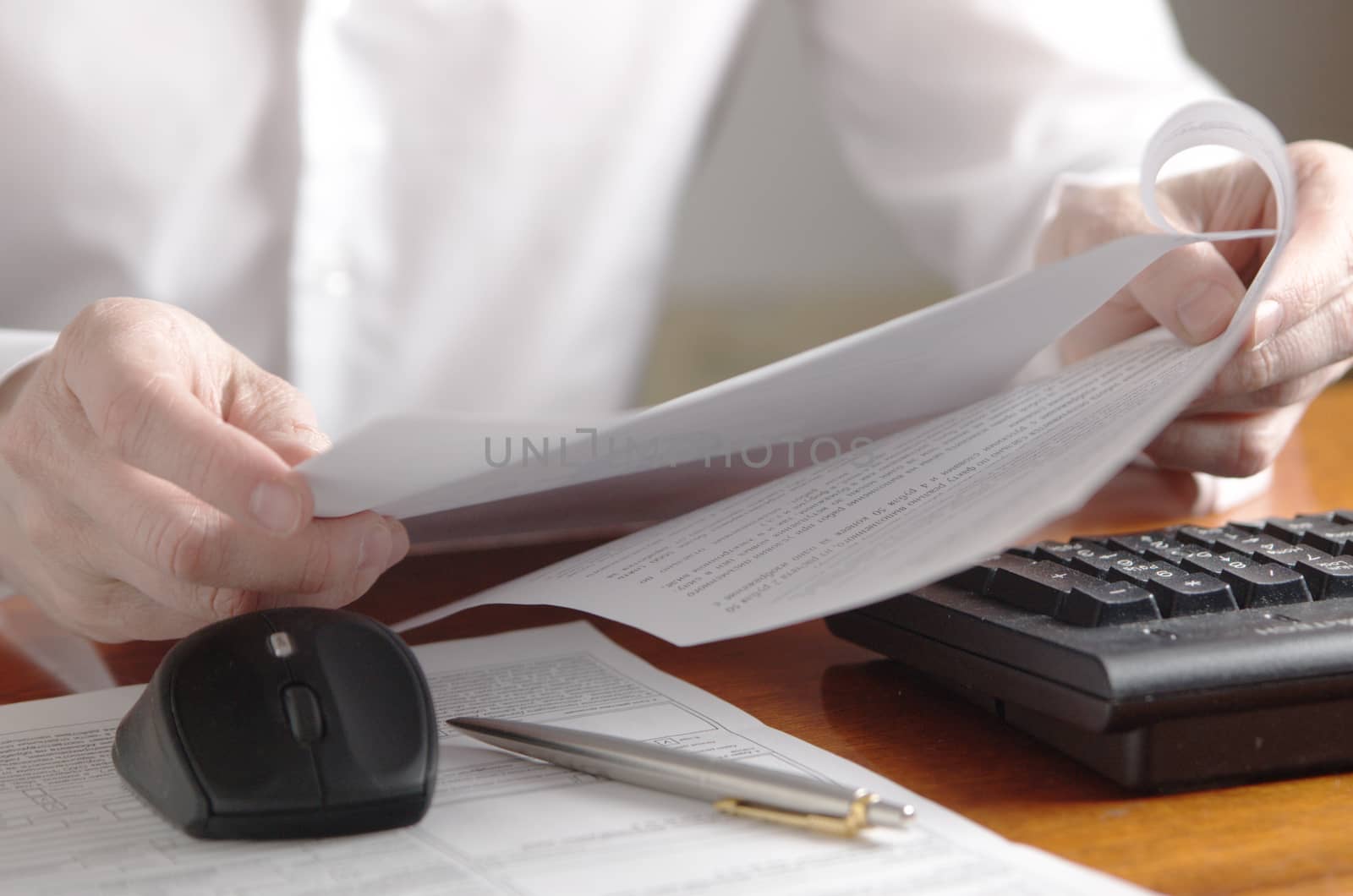 Hands with a document on a computer keyboard