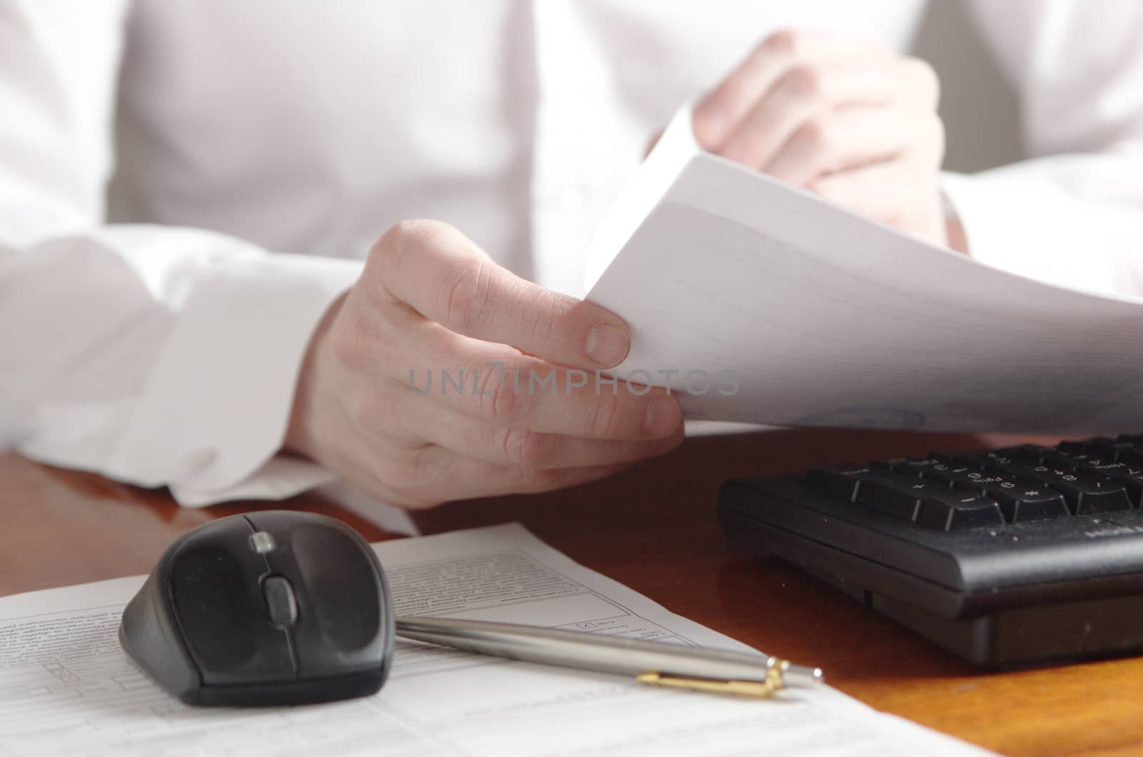 Hands with a document on a computer keyboard