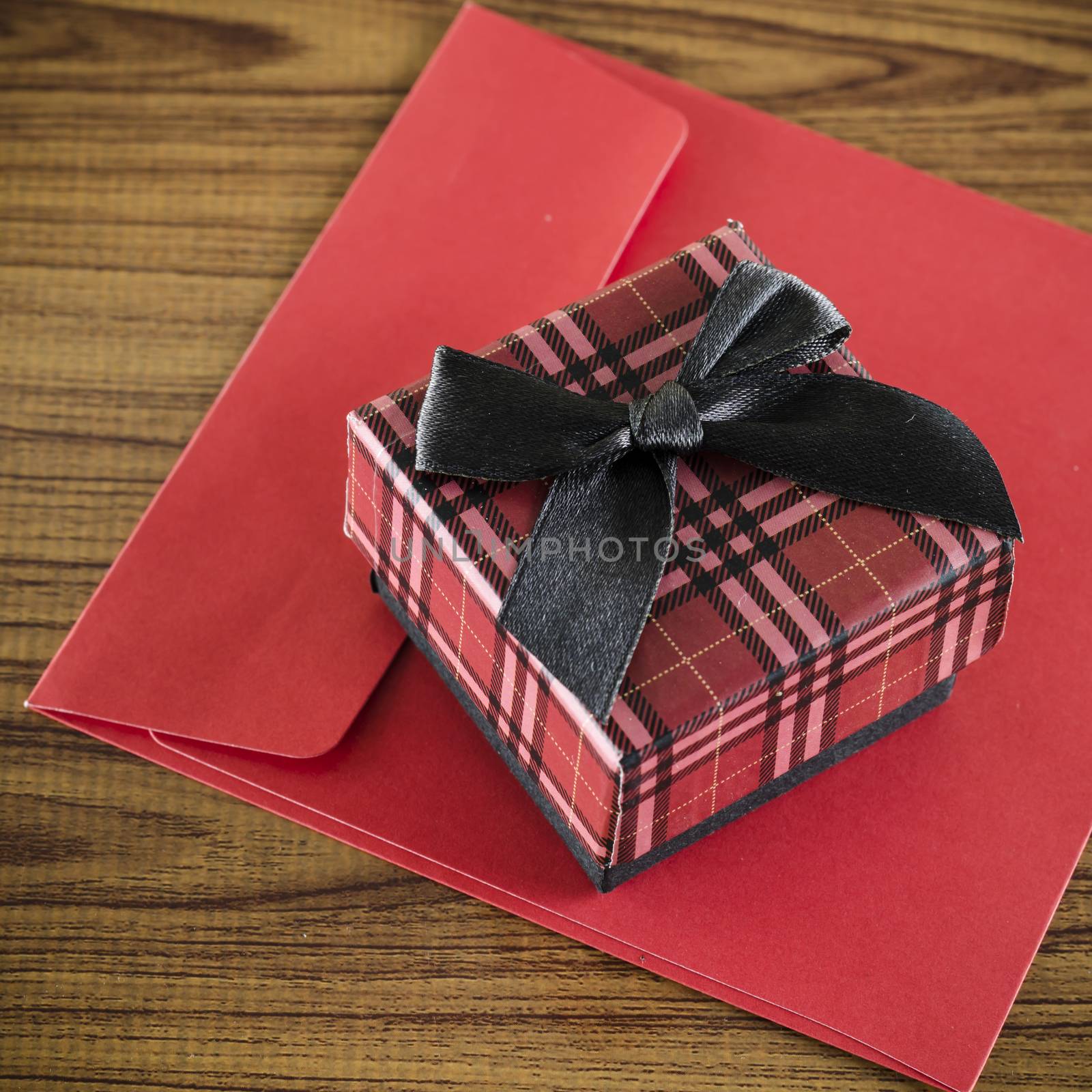 red gift box and envelope on wood background