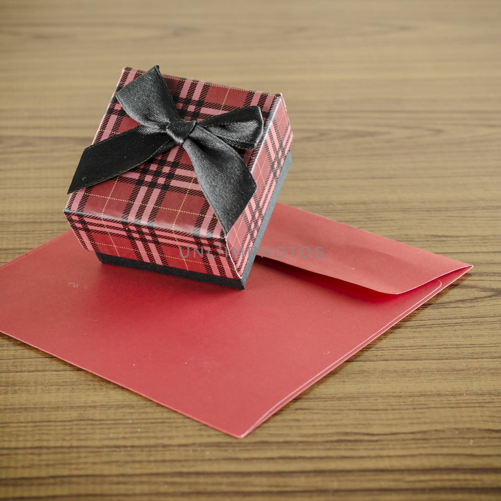 red gift box and envelope on wood background