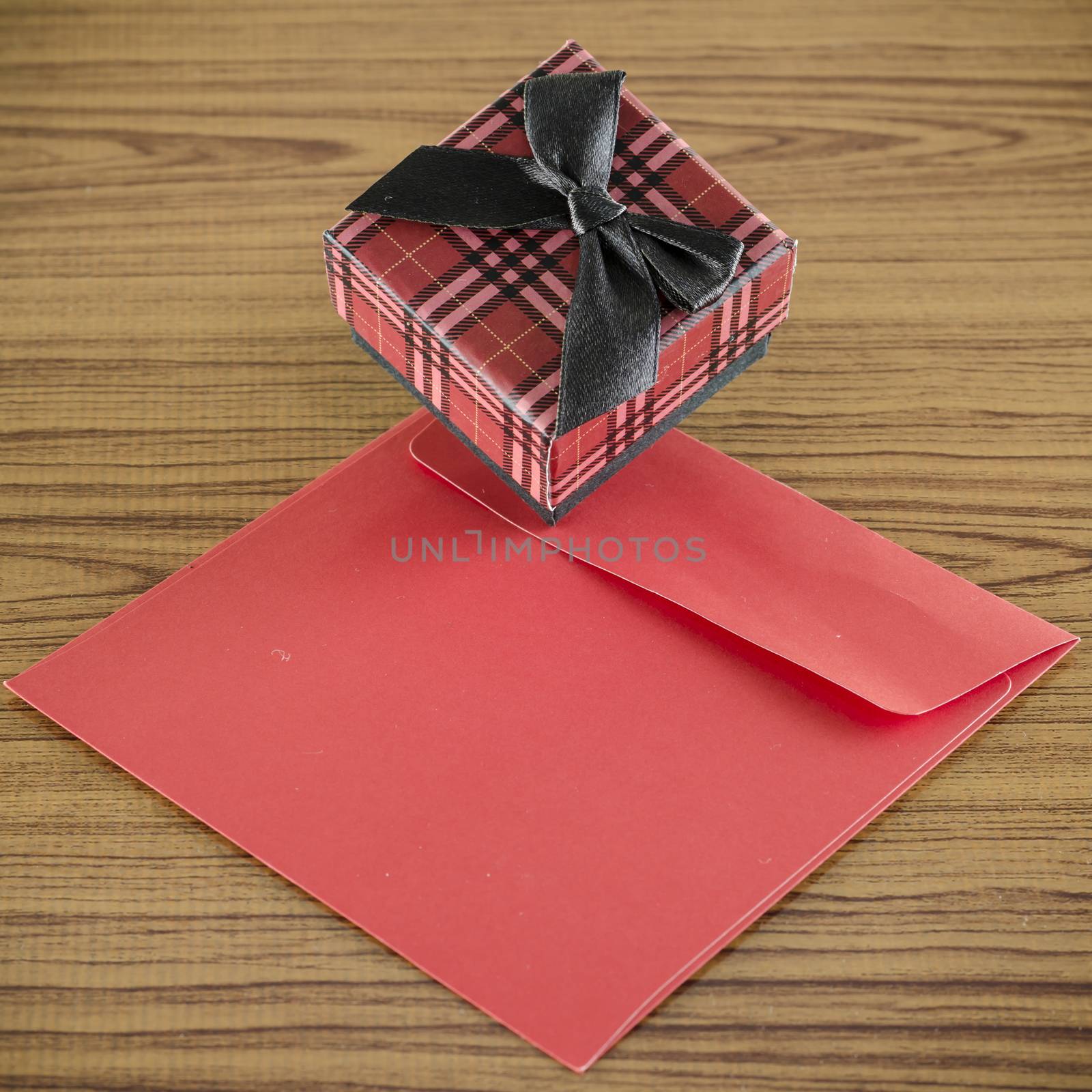 red gift box and envelope on wood background