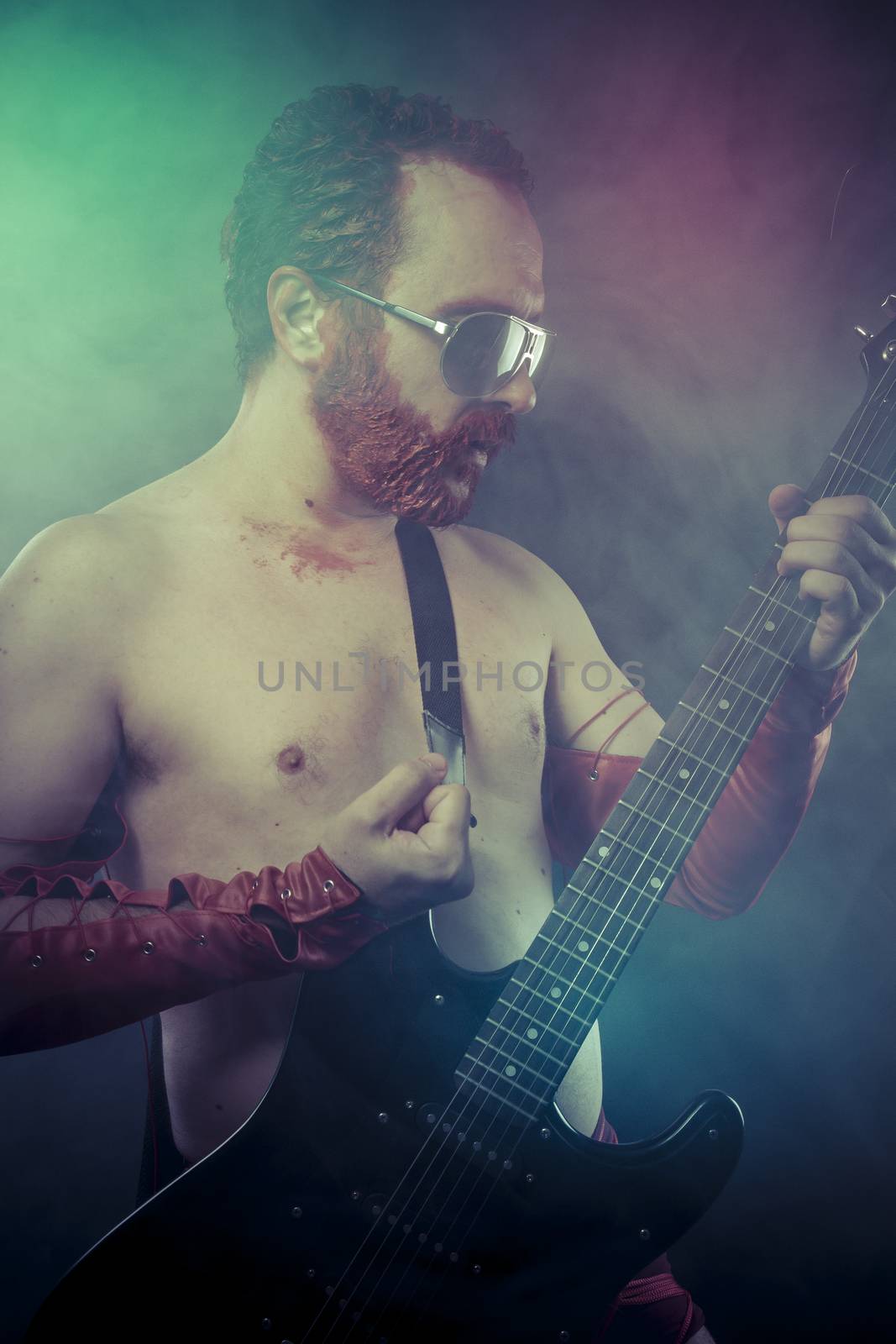 Metal, rocker man with electric guitar in a rock concert by FernandoCortes