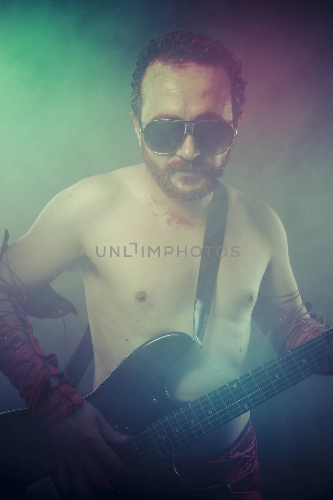 Music, rocker man with electric guitar in a rock concert by FernandoCortes