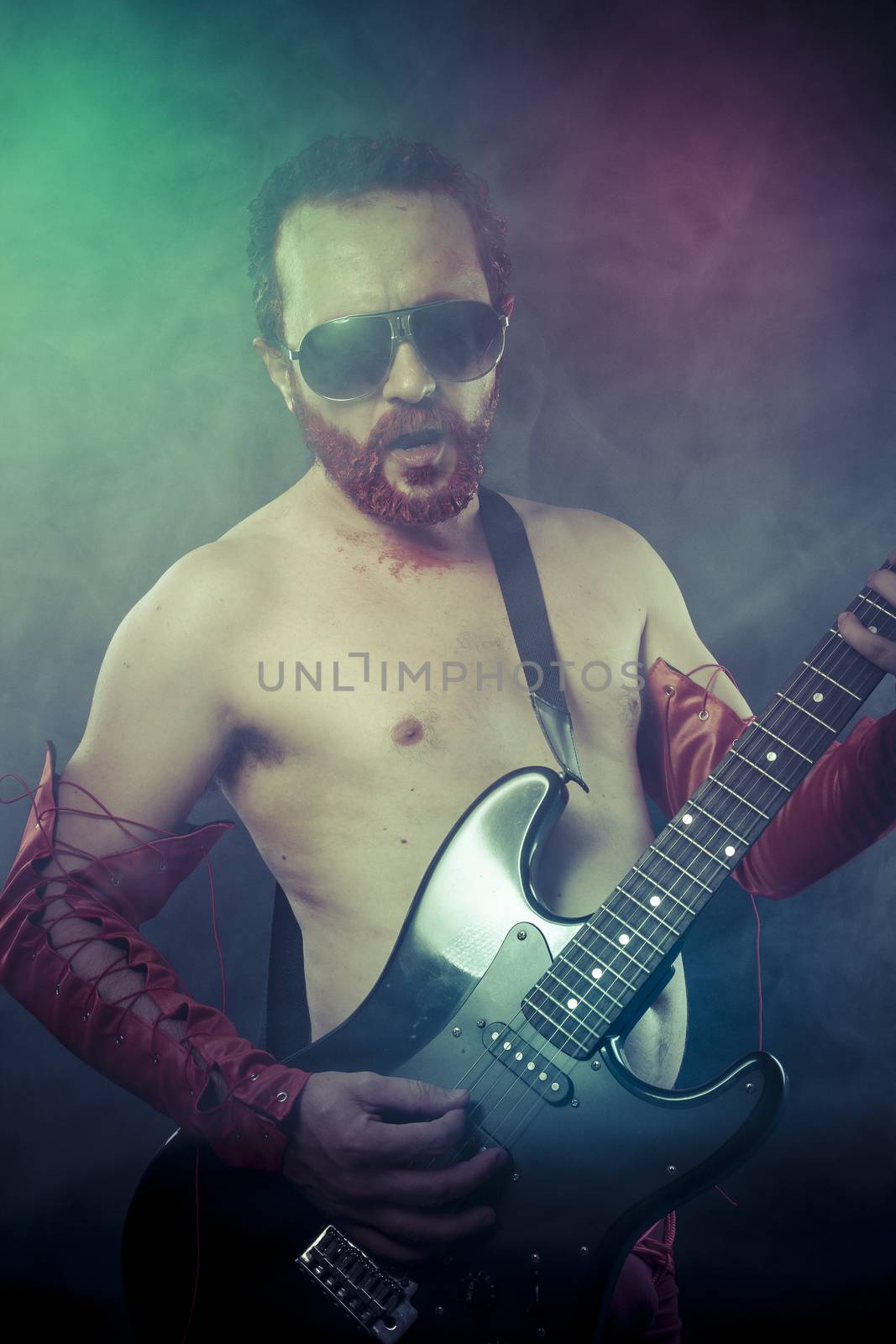 rocker man with electric guitar in a rock concert by FernandoCortes