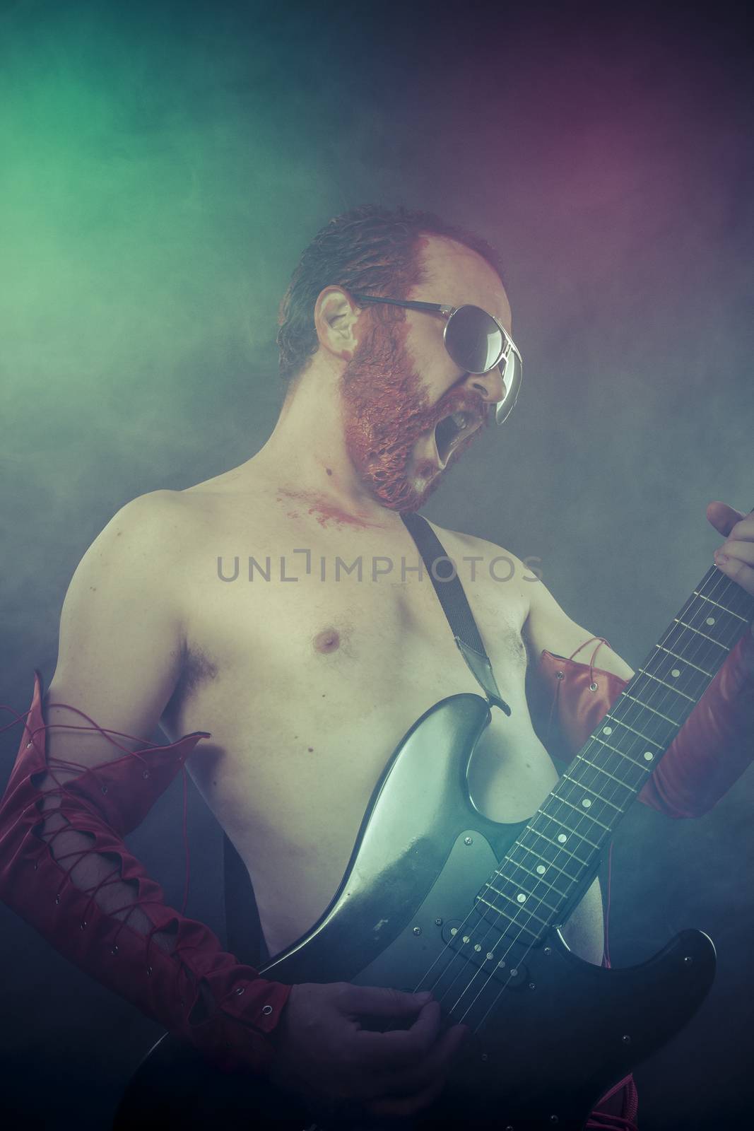 rocker man with electric guitar in a rock concert by FernandoCortes