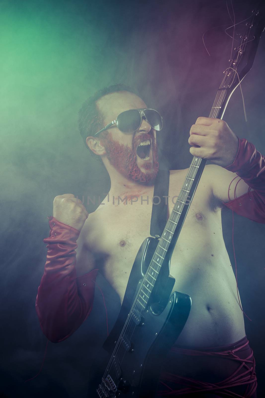 Metal, rocker man with electric guitar in a rock concert