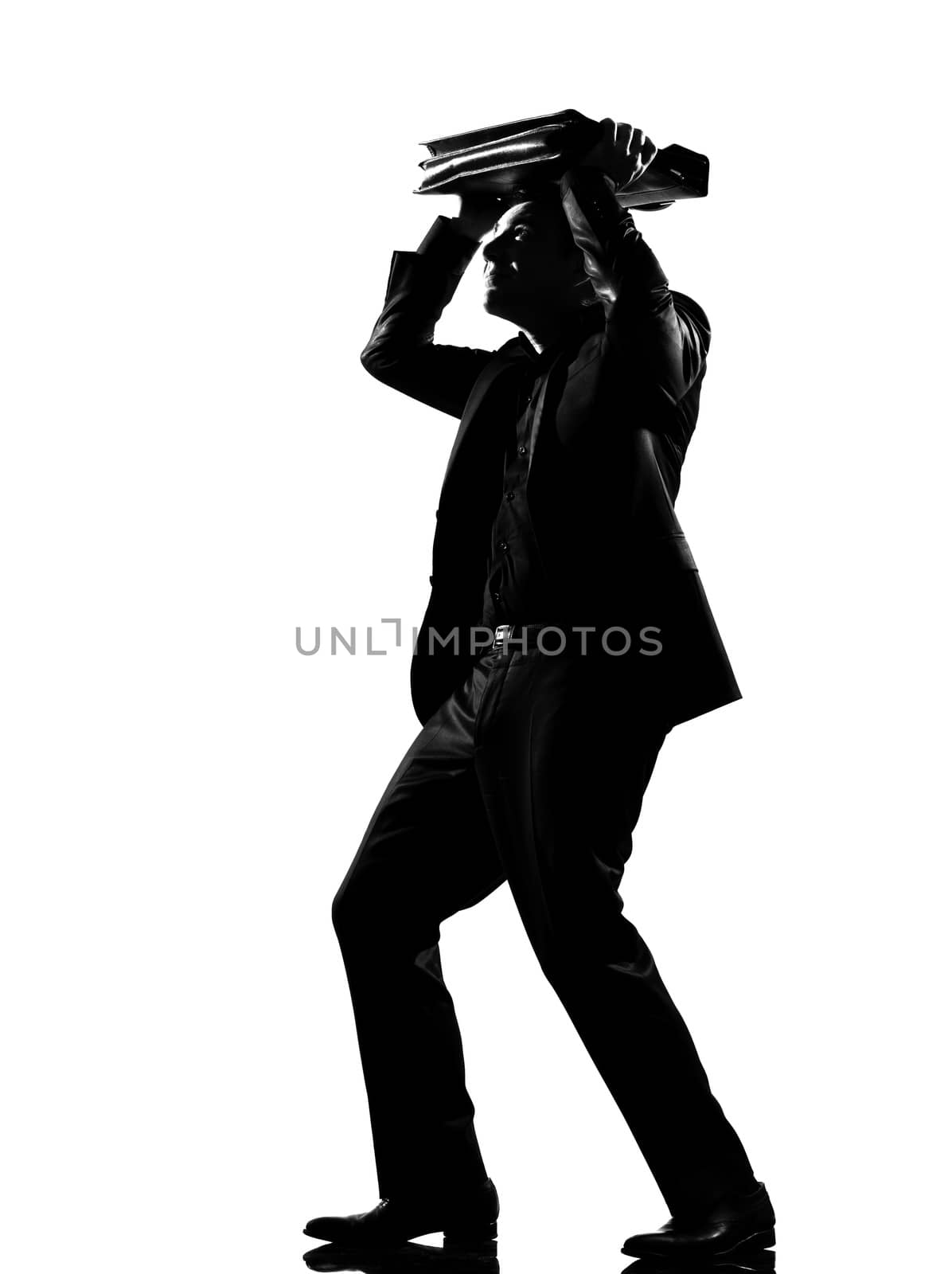 silhouette  business man shielding with his briefcase expressing fear afraid behavior full length on studio isolated white background