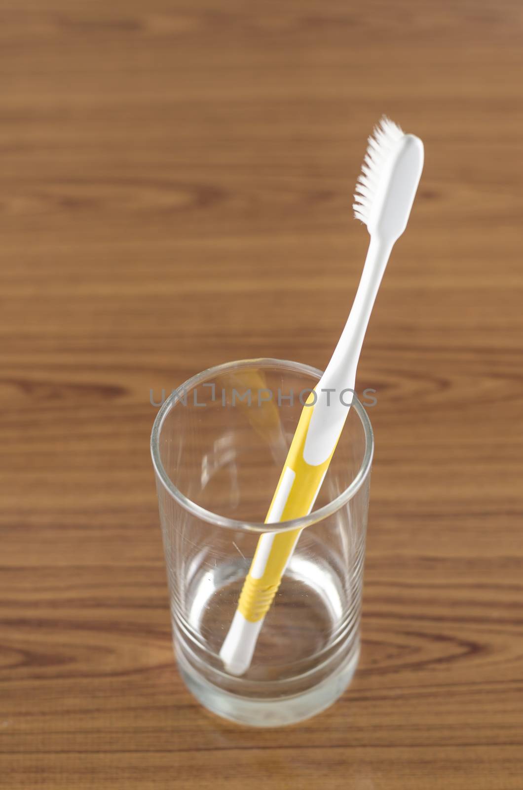 toothbrush in glass on wood background