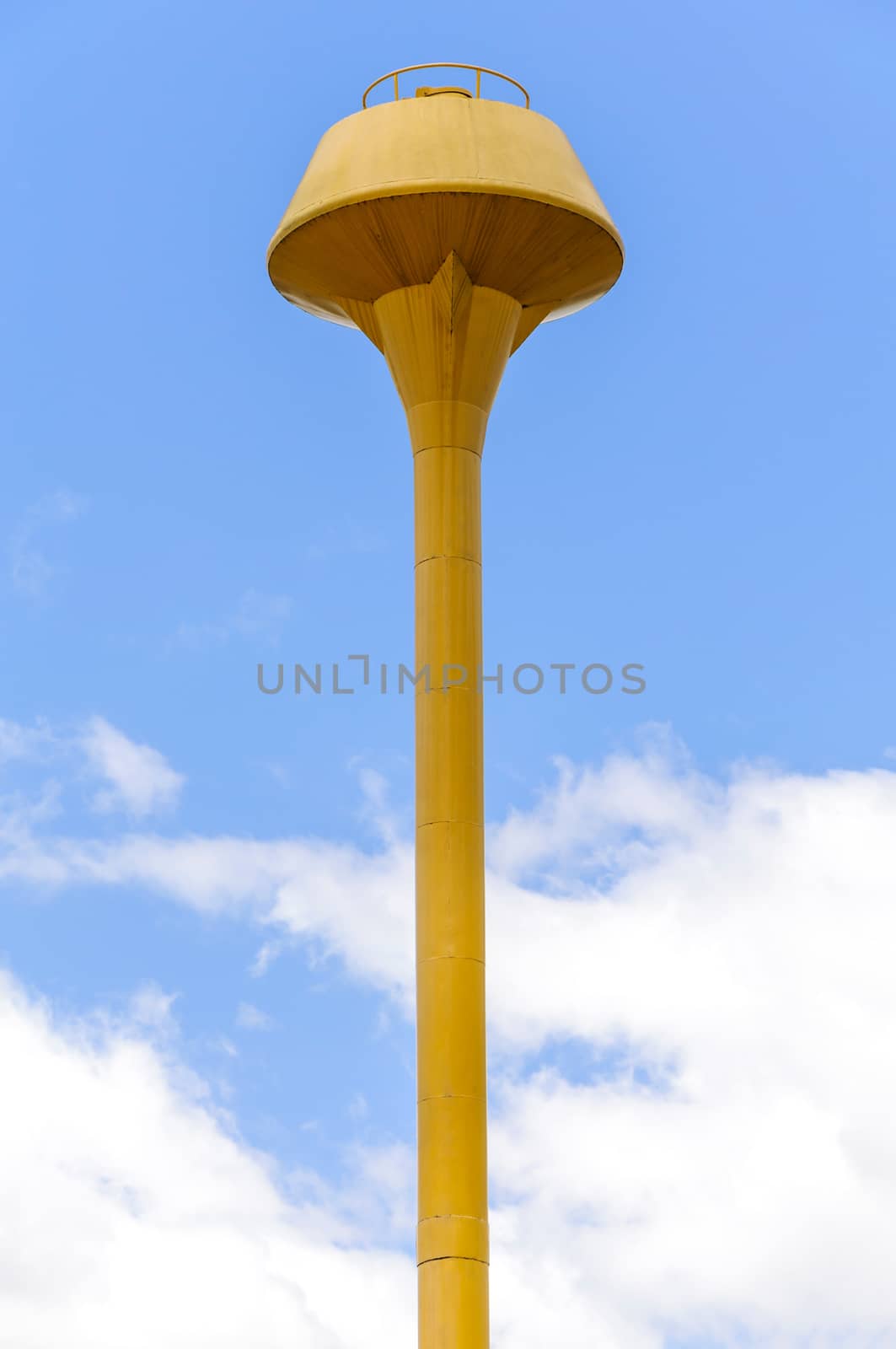 Yellow water tank on blue sky with clouds