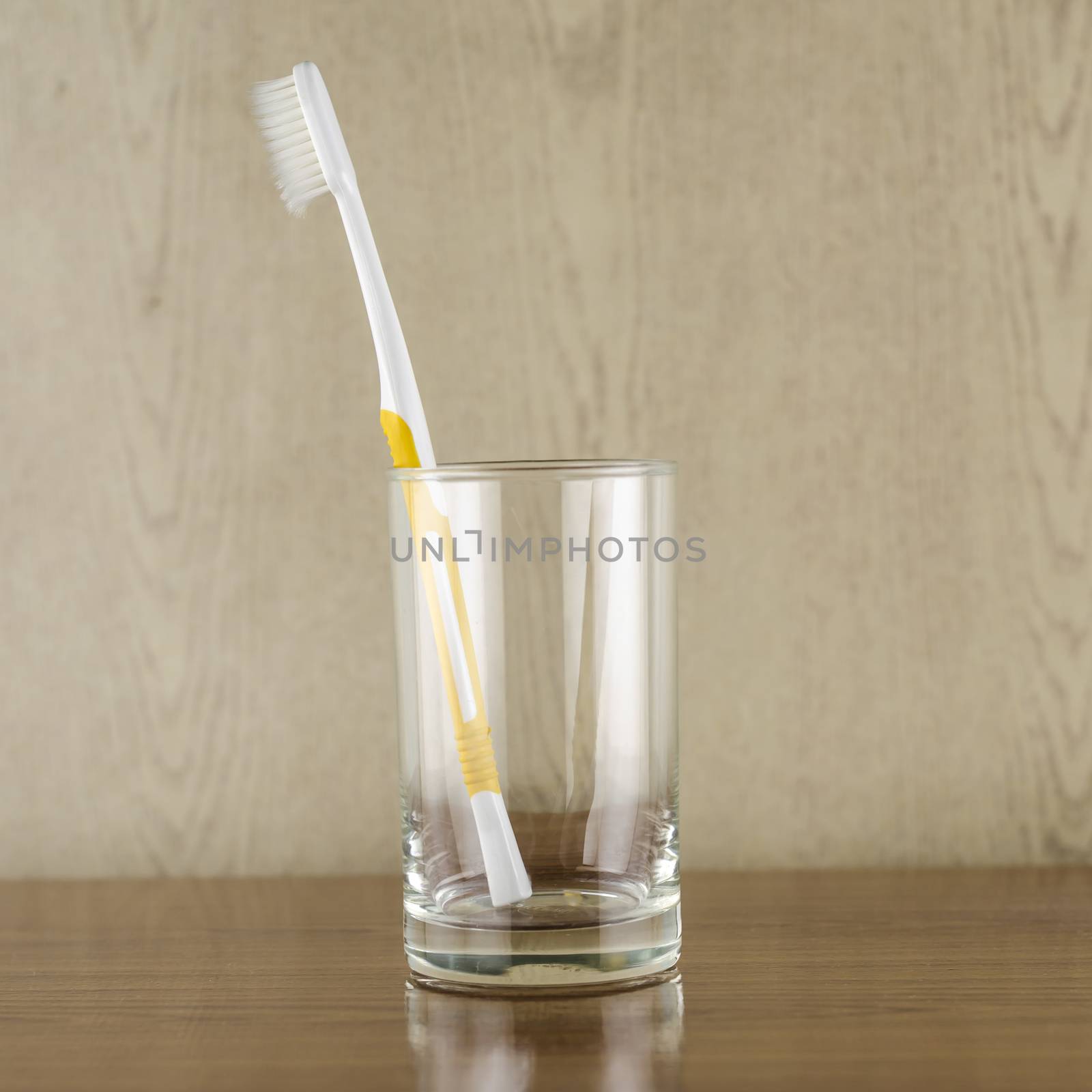 toothbrush in glass on wood background