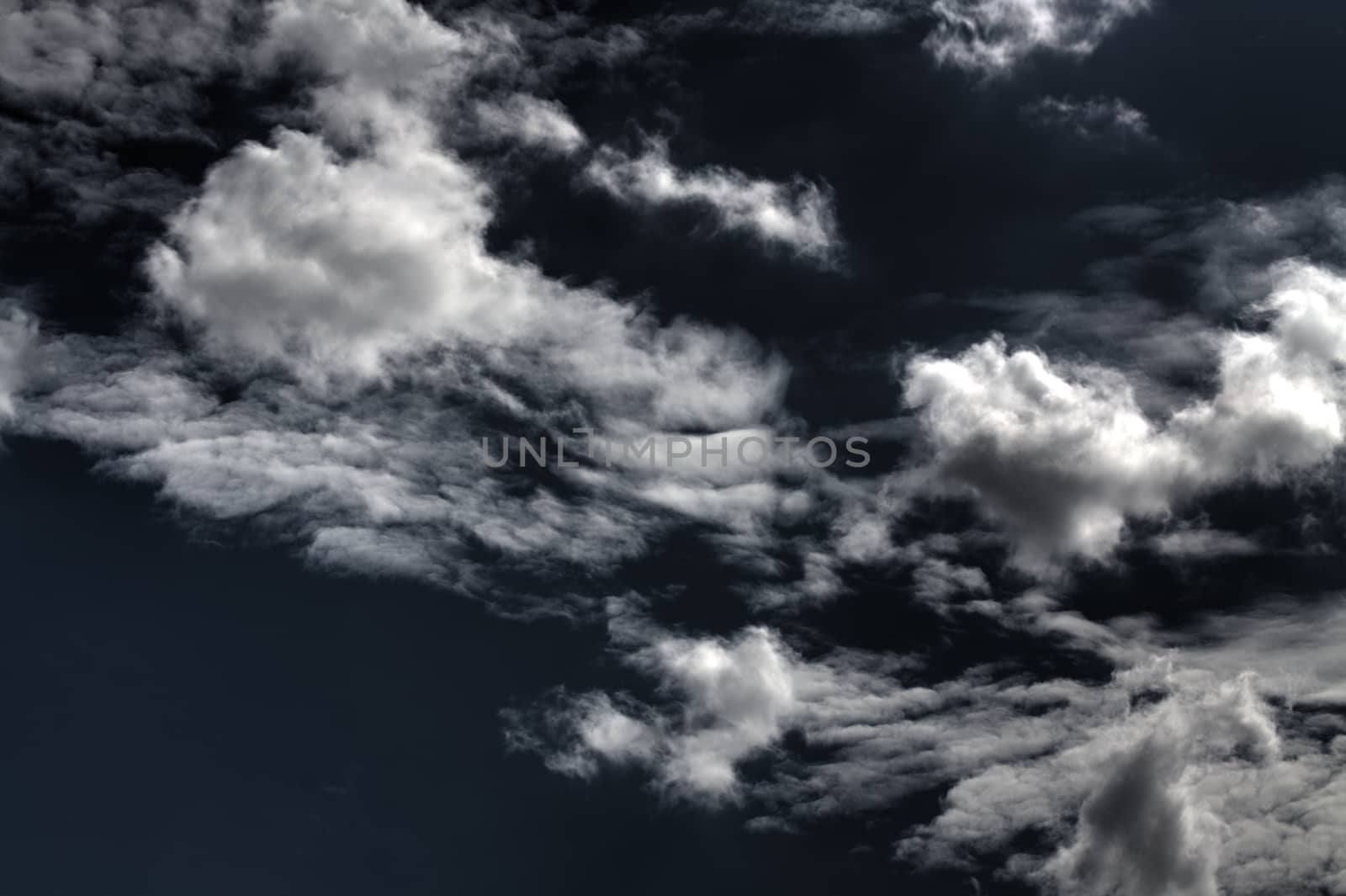 Panoramic Expanse of Dark Blue Sky with Diagonal Display of Dramatic White Cumulus Clouds