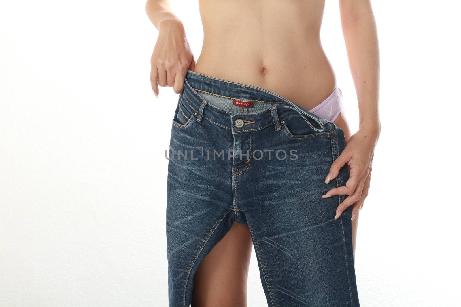 Sexy female take off jeans, isolated on white background.