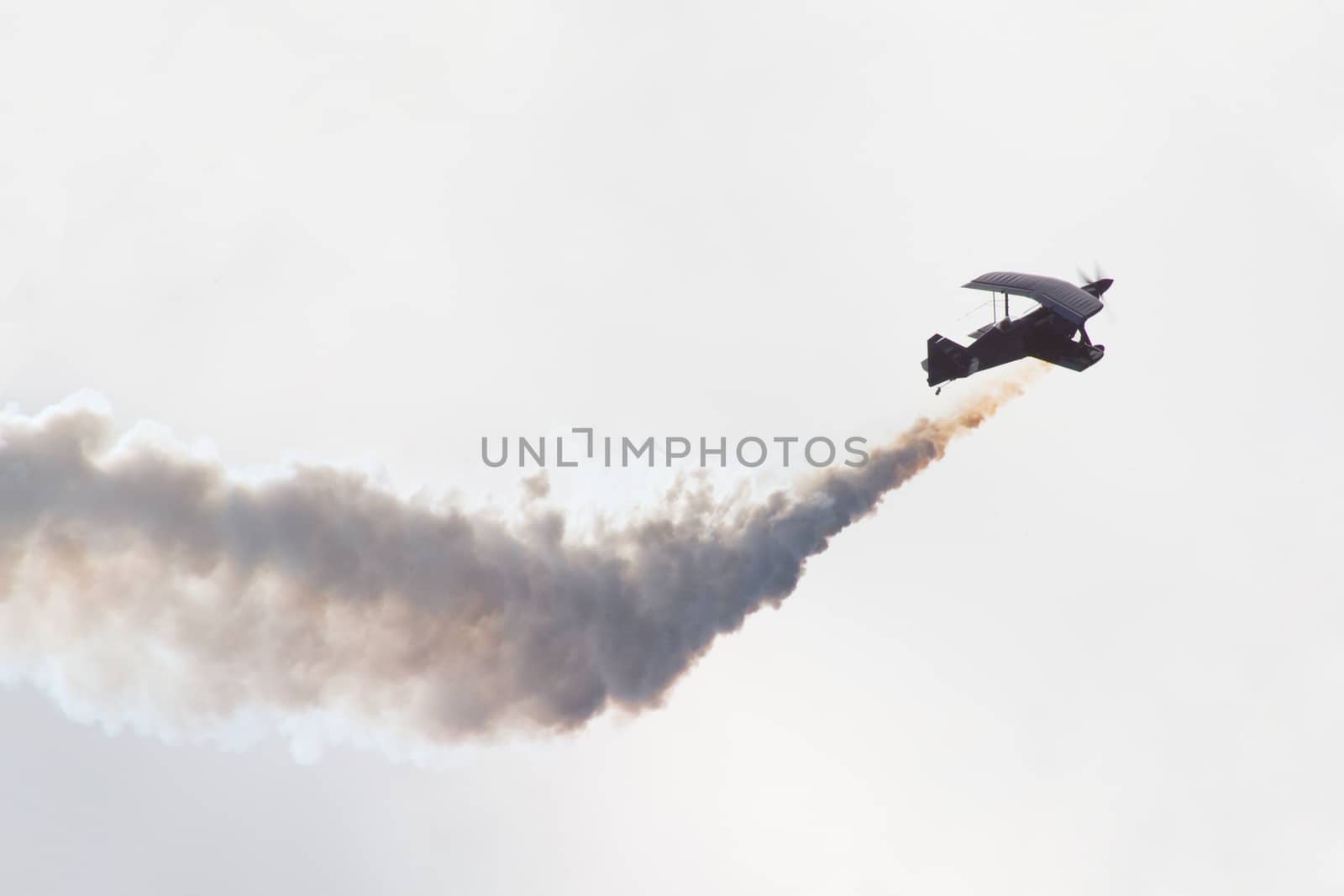 Biplane performing aerobatics with smoke