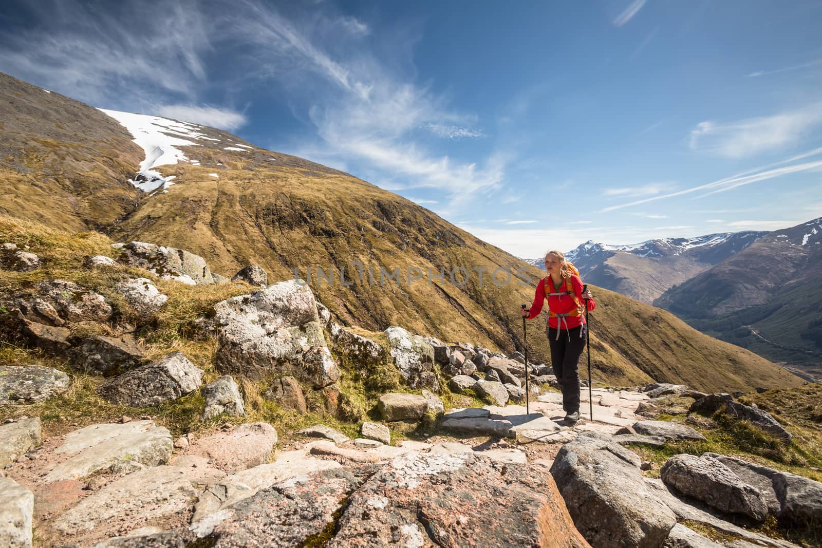 Pretty, young female hiker going uphill