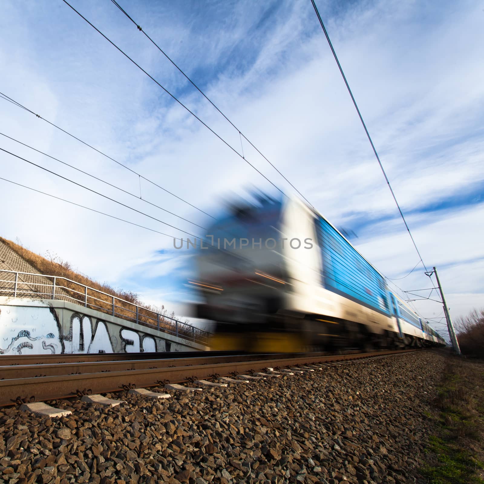 Fast train passing under a bridge on a lovely summer day by viktor_cap
