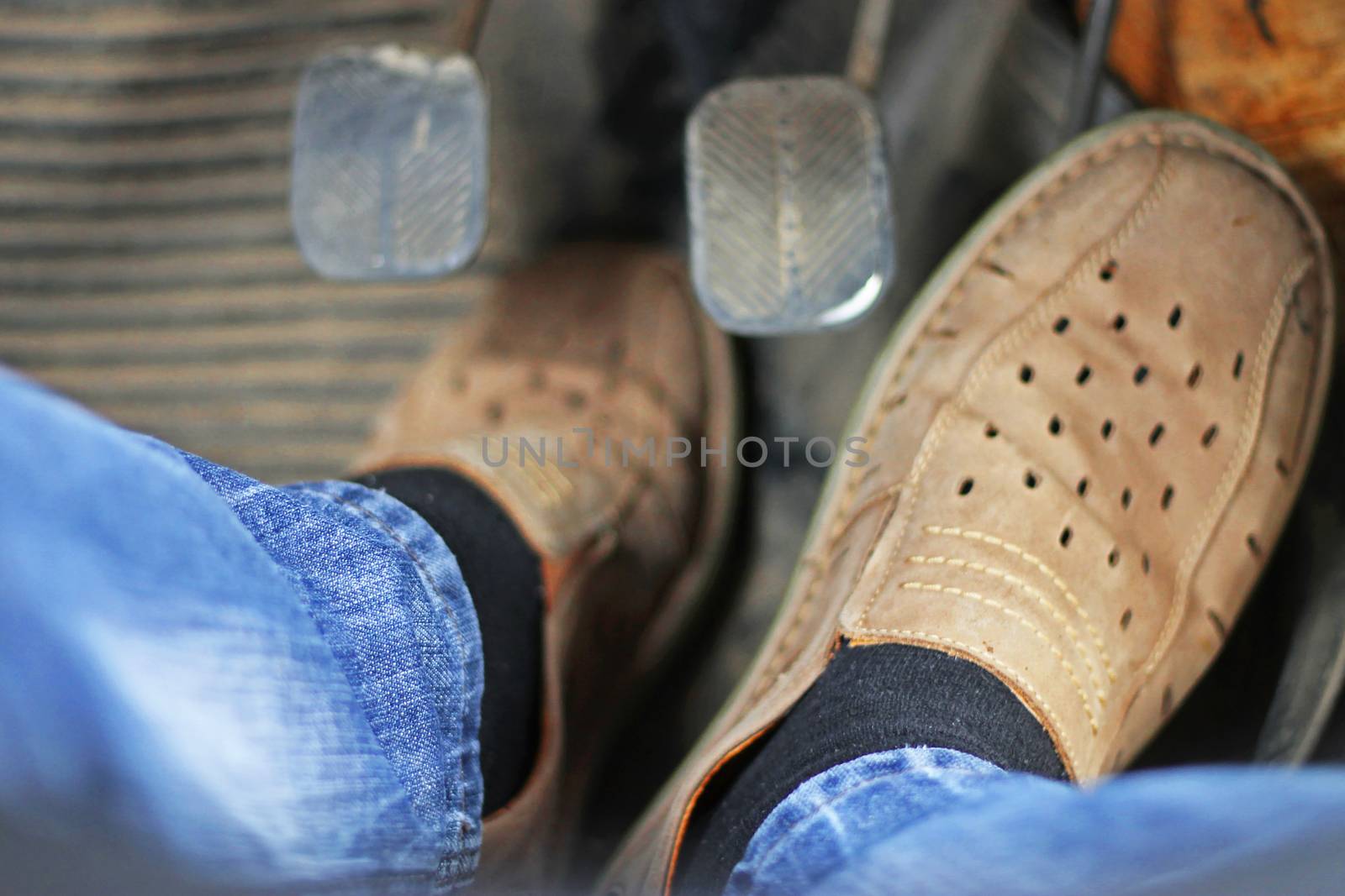 Mans feet pushing on the accelerator of automobile