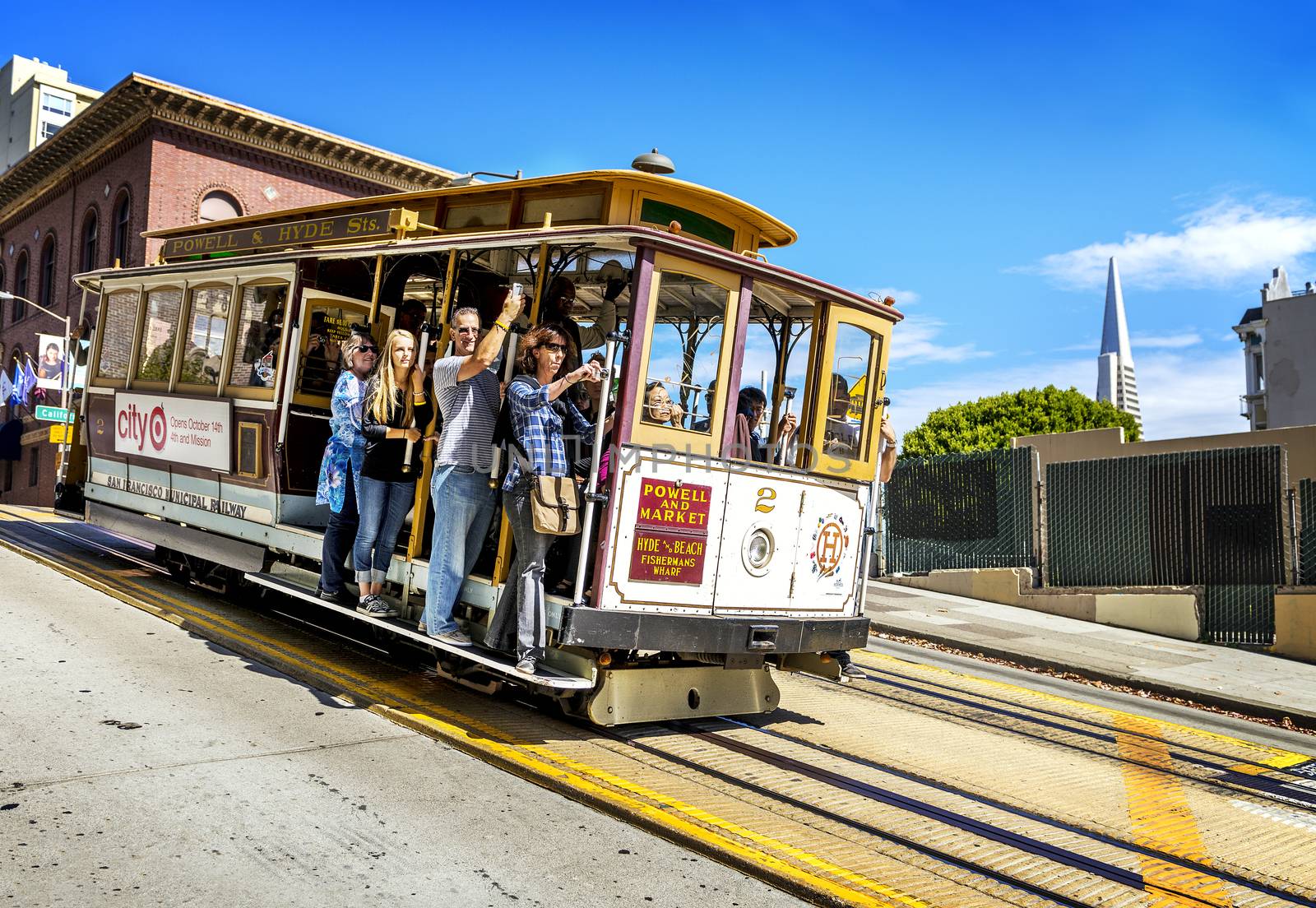 SAN FRANCISCO - OCT 06: Passengers enjoy a ride in a cable car on Oct 06, 2012 in front of famous Transamerica building in San Francisco. It is the oldest mechanical public transport in San Francisco which is in service since 1873. 