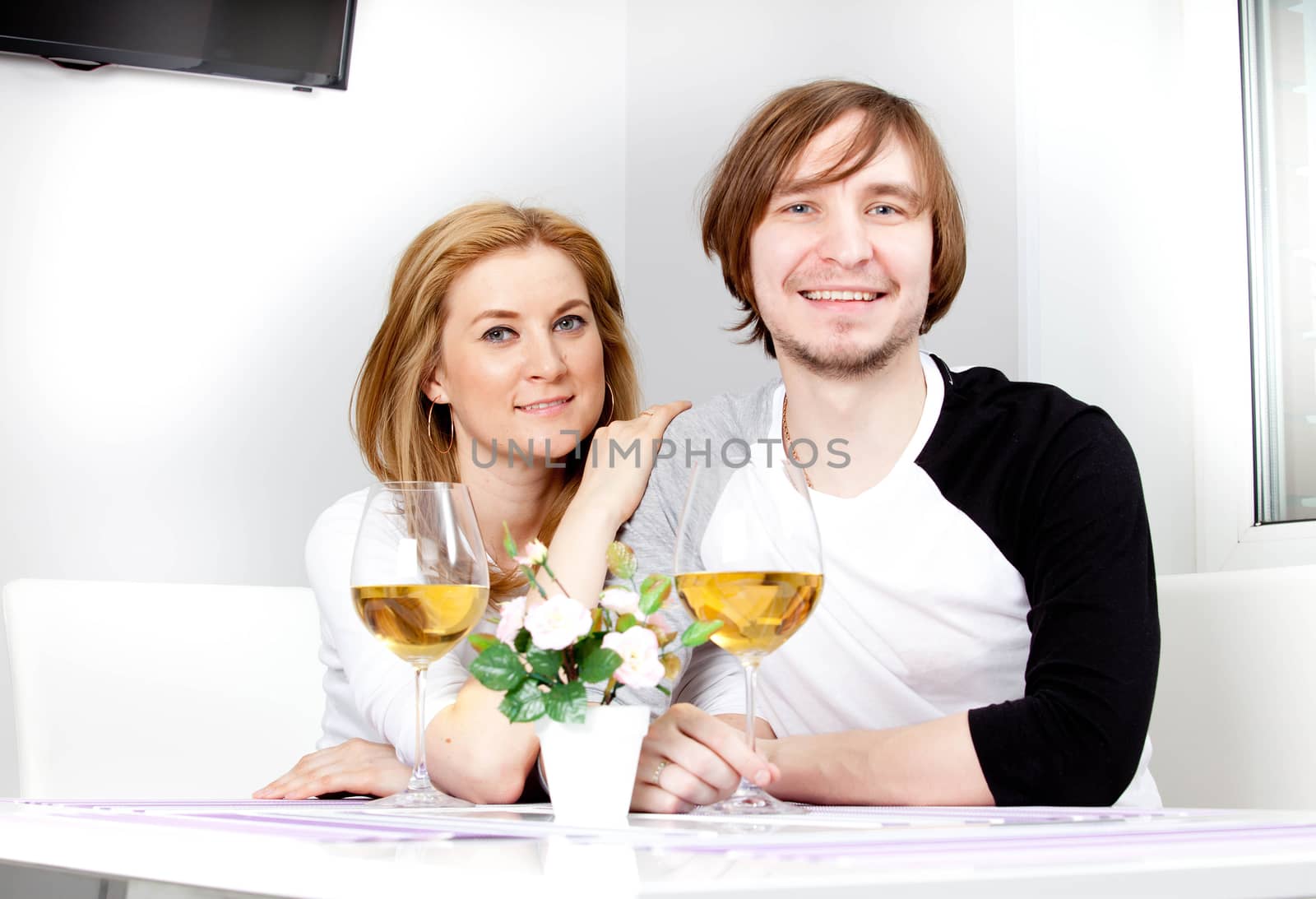 young woman in home having meal and wine with her husband
