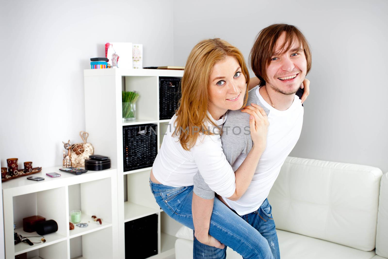 Man carrying girlfriend on his back in home