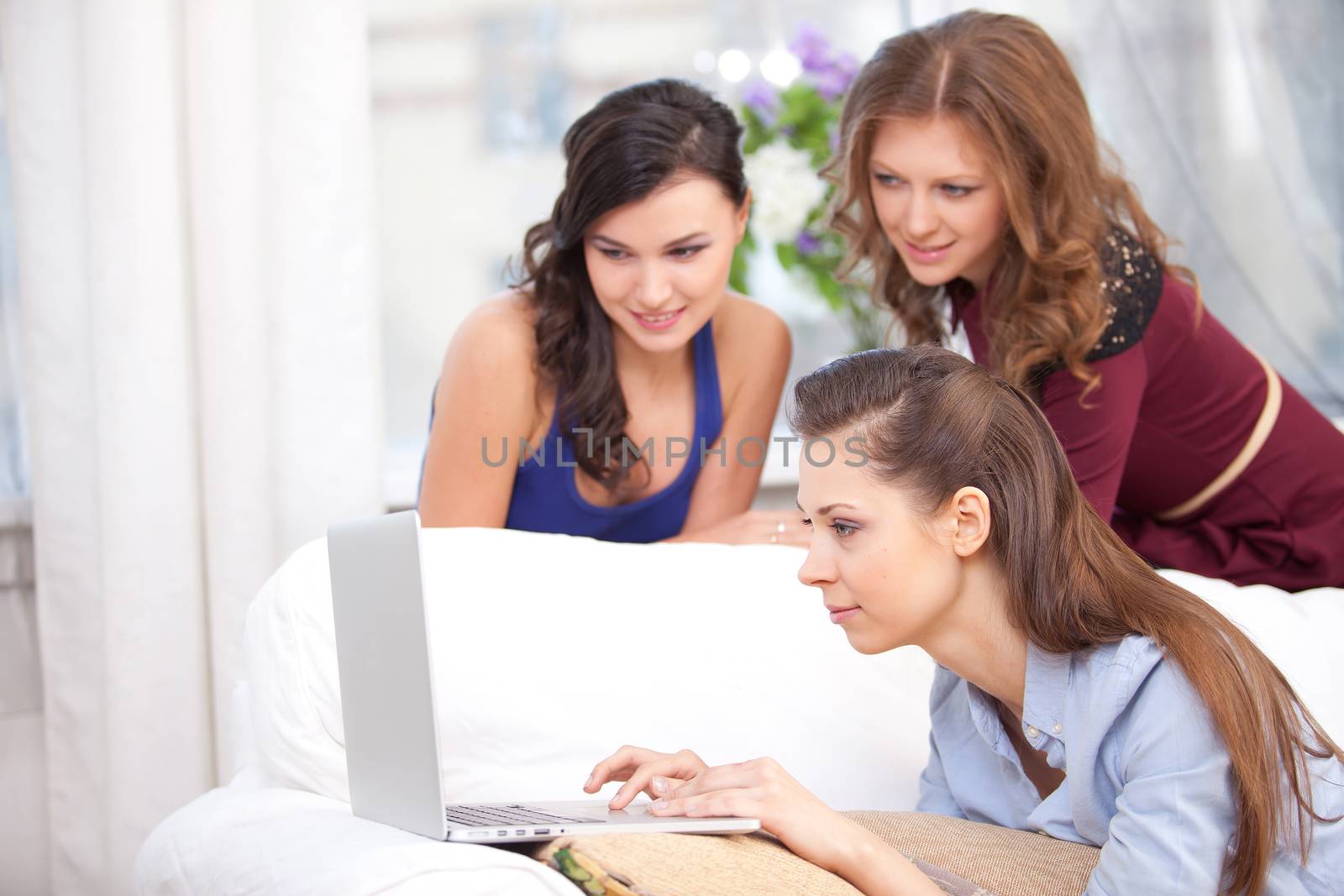 Young girl using a laptop on a sofa